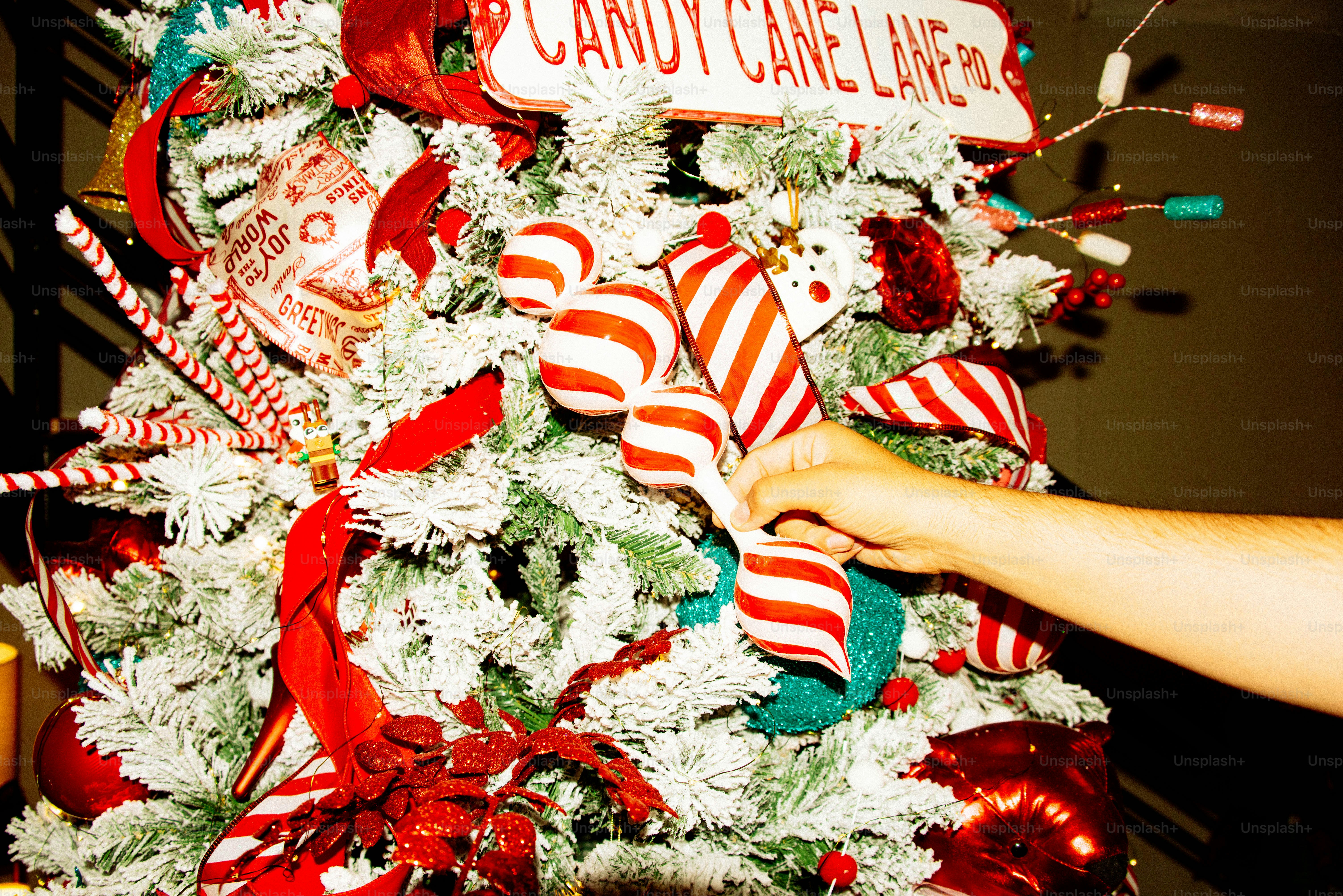 Decorar à mão uma árvore de Natal com bengalas de doce.