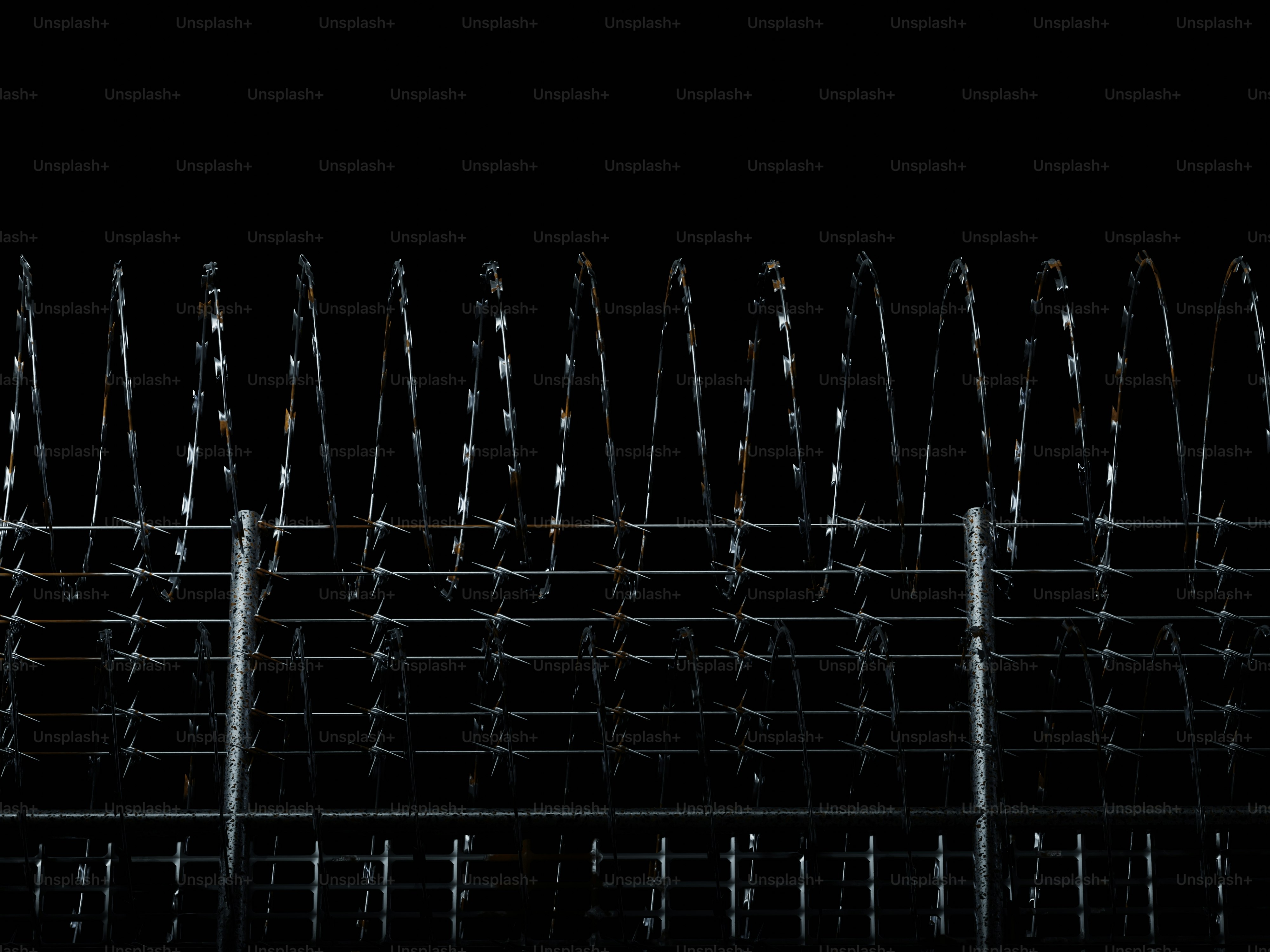 Stacheldrahtzaun vor schwarzem Hintergrund