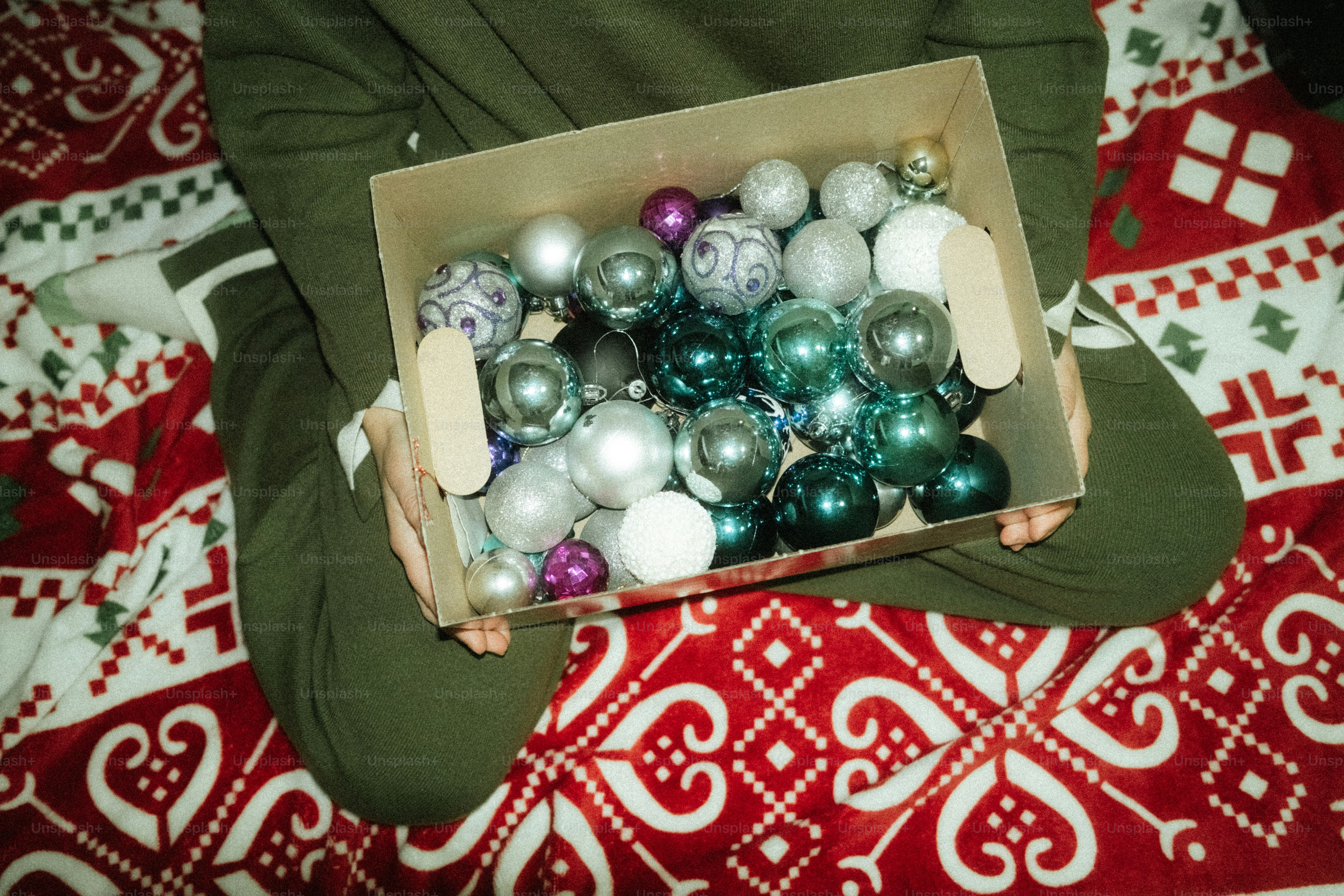 Hands holding a box of christmas ornaments