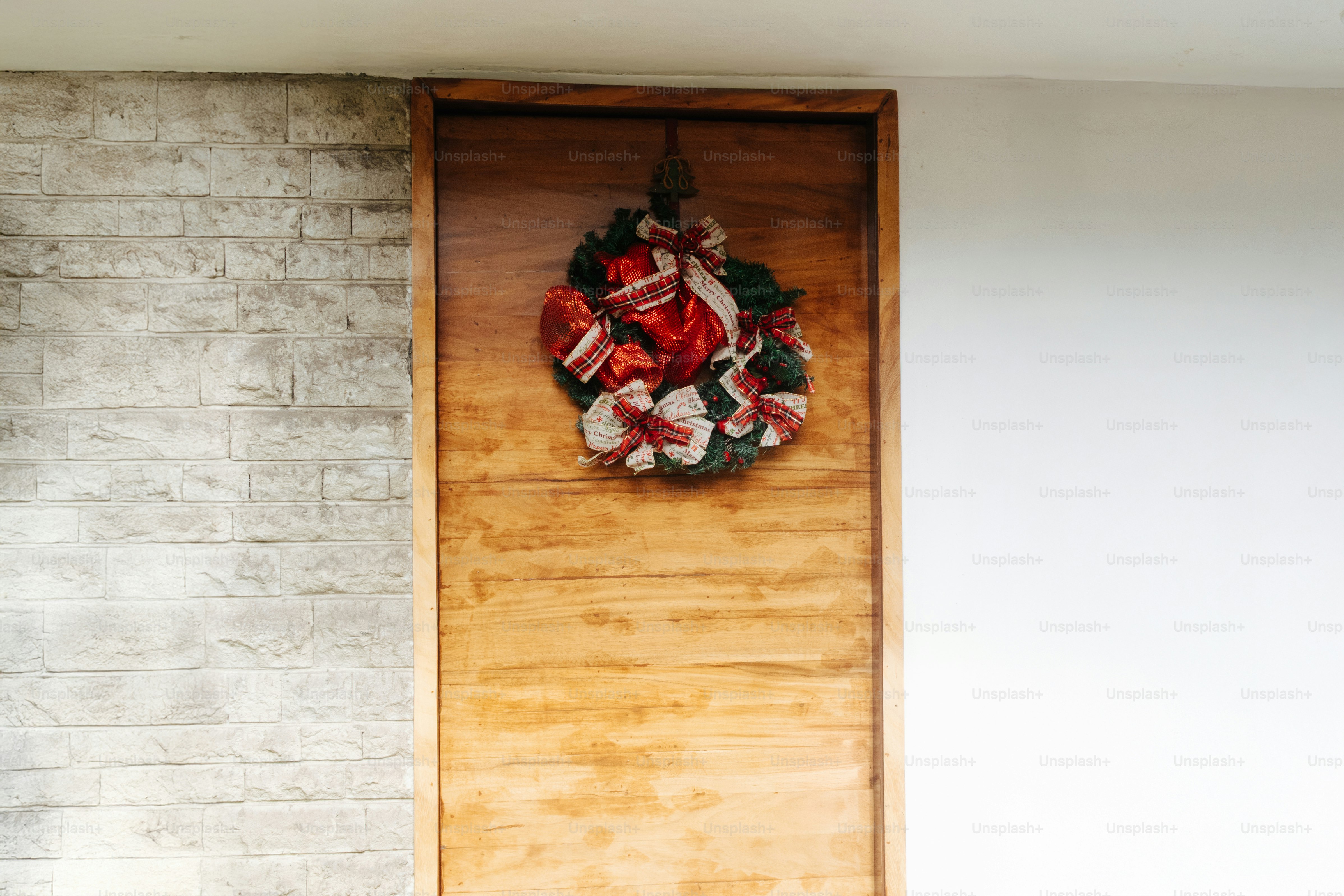 A wooden door with a festive christmas wreath.