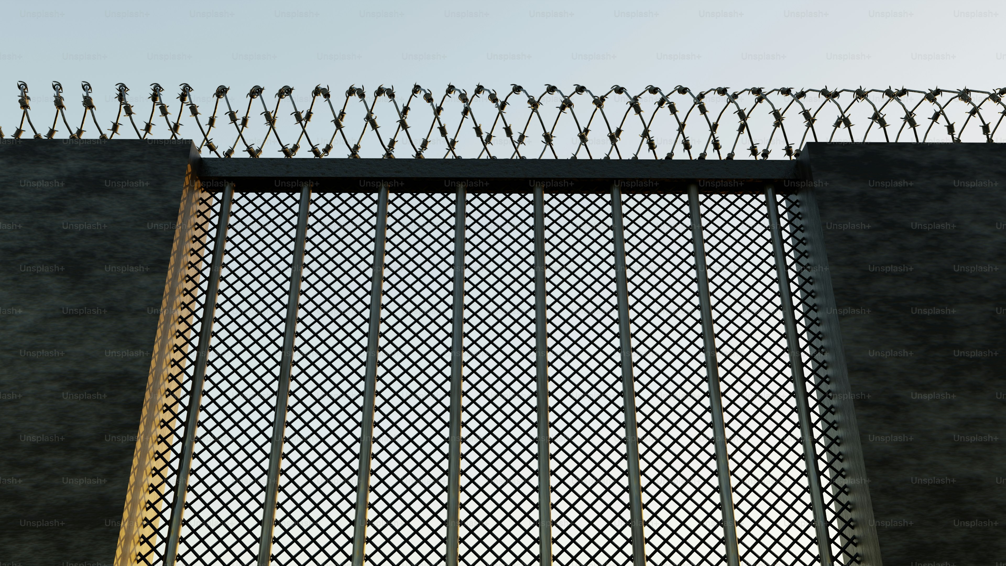 Ein hoher Zaun mit Stacheldraht obendrauf.