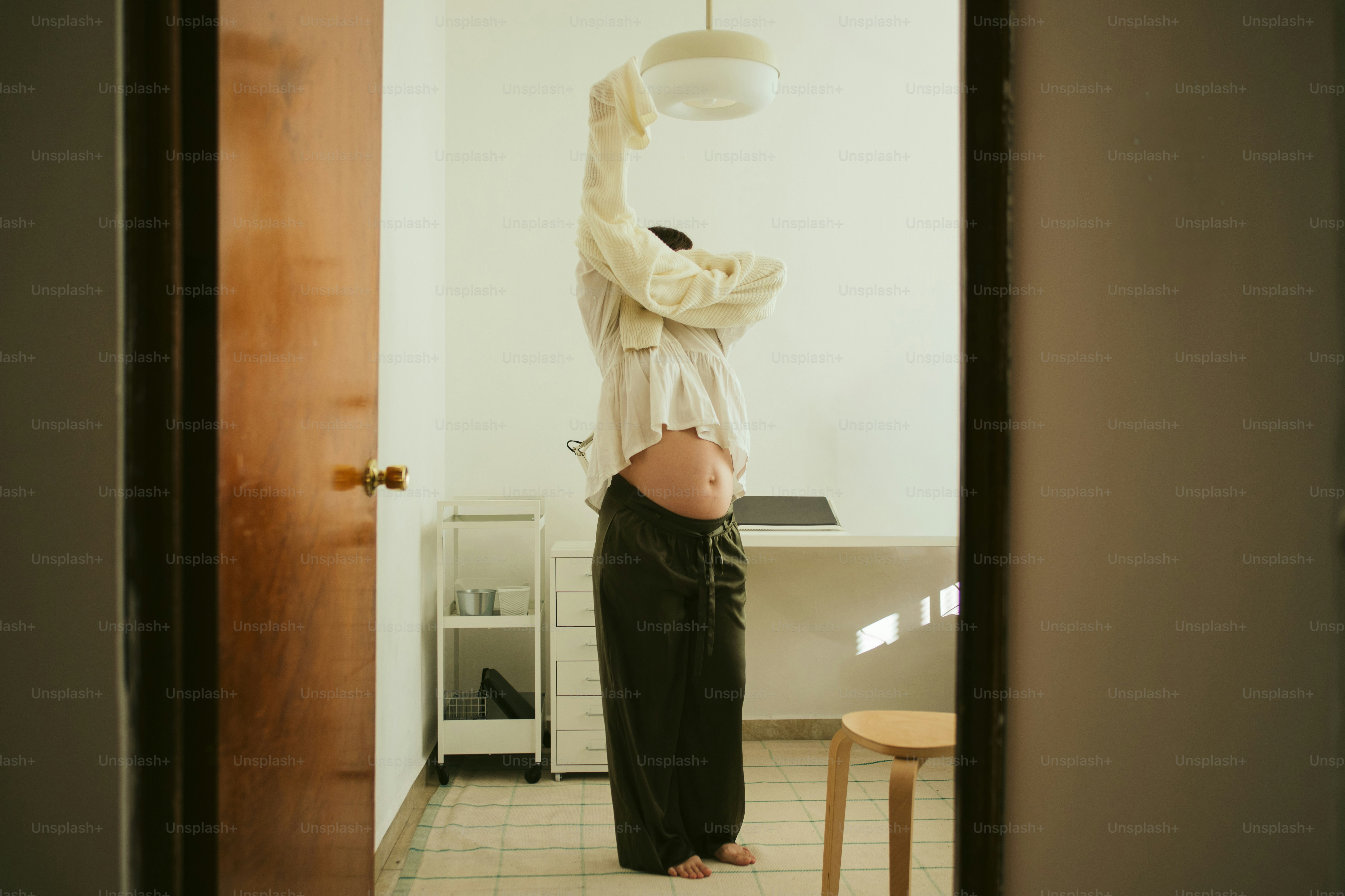 Person changing clothes in a minimalist room.