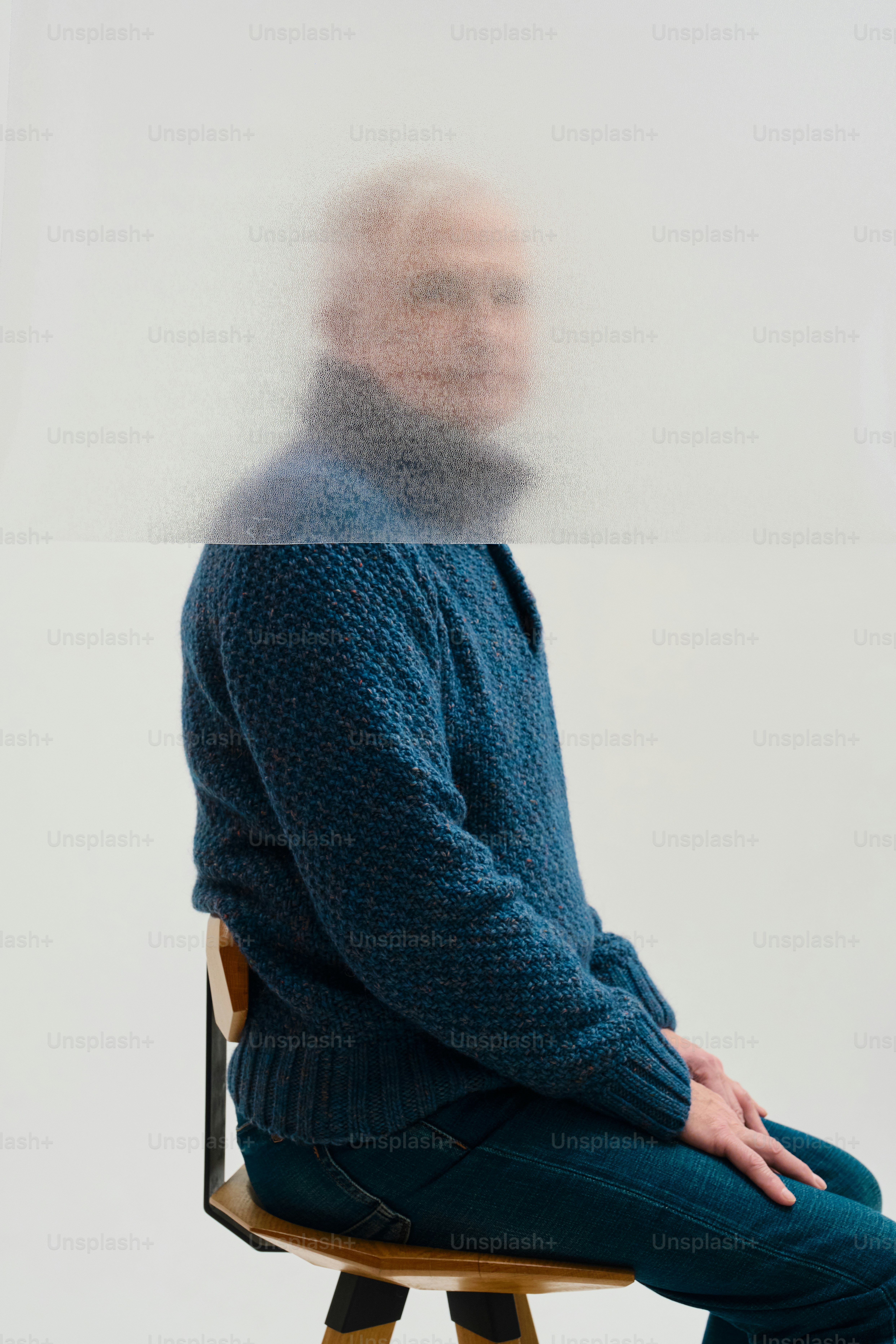 Homme en pull bleu assis sur une chaise