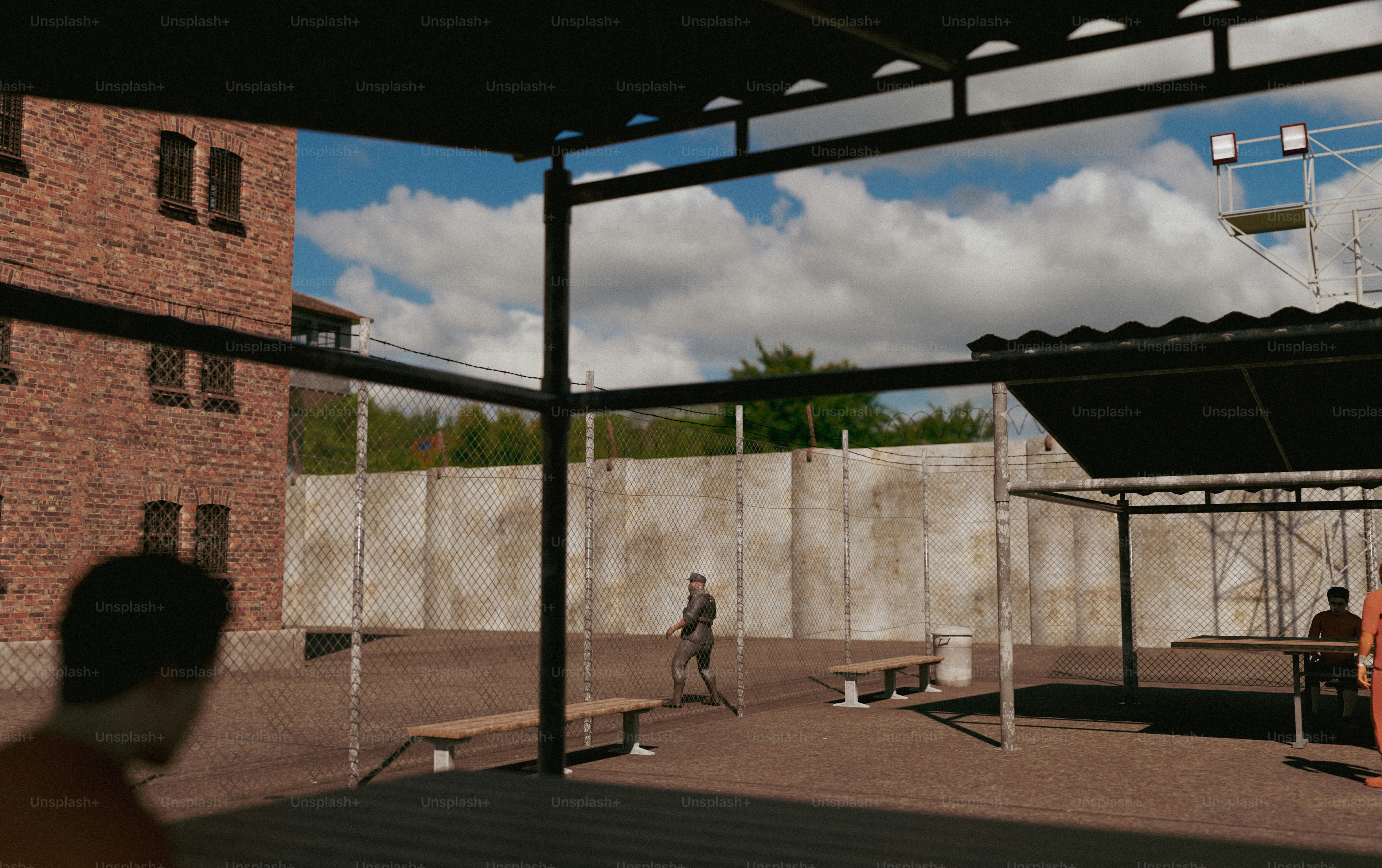 Menschen in einem Gefängnishof mit Backsteingebäuden.