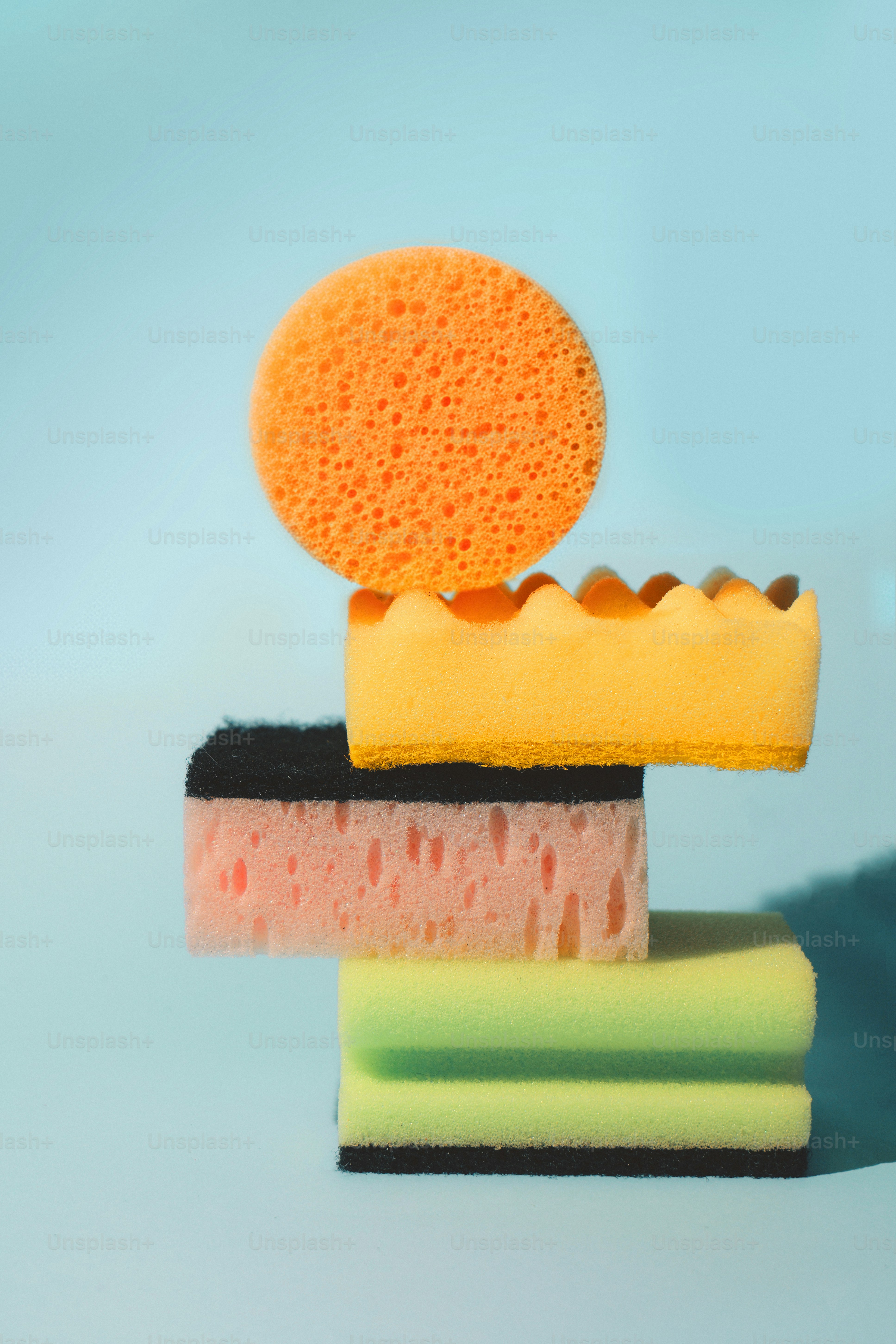 Pile d’éponges nettoyantes colorées sur fond bleu