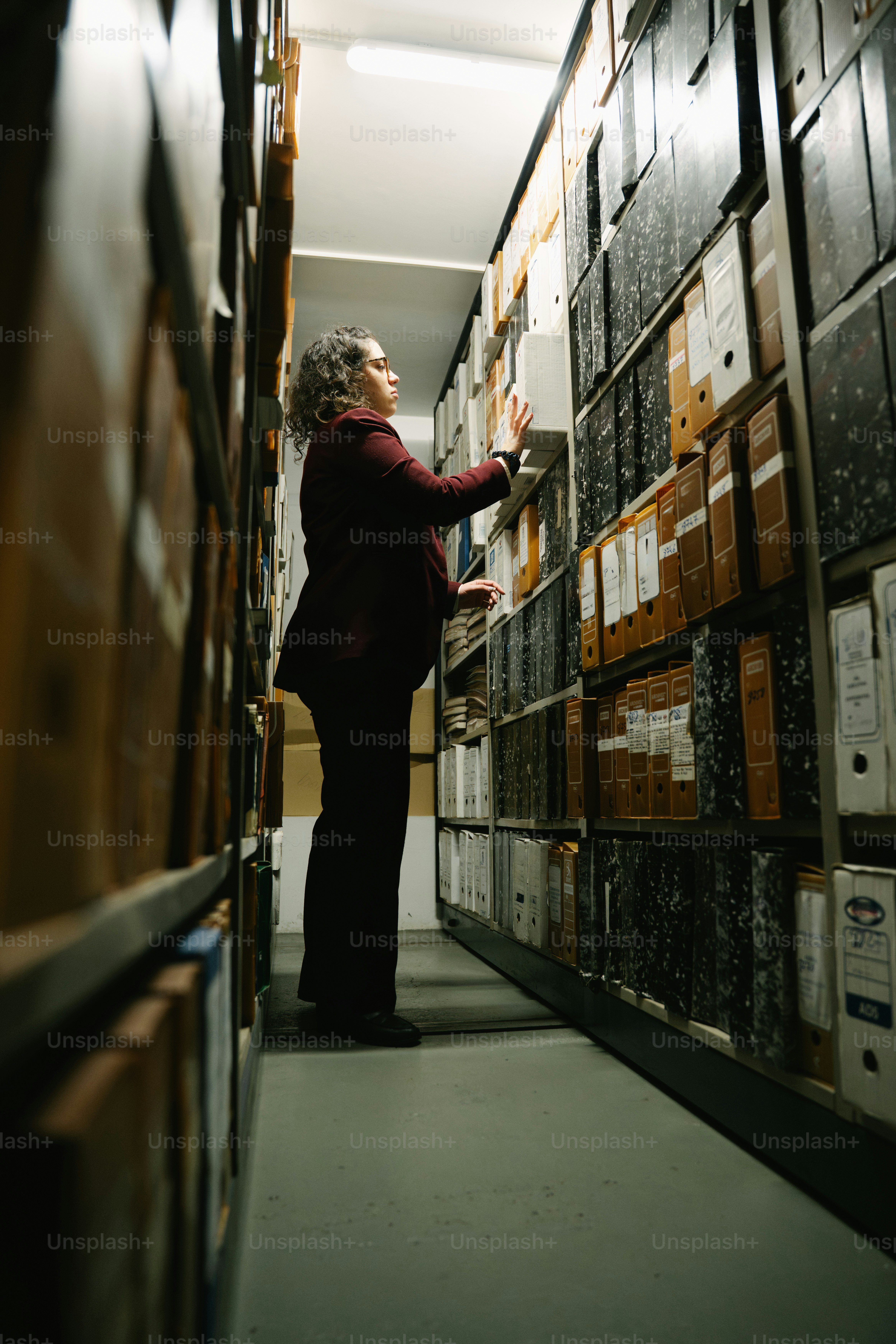 Person reaching for a file in a crowded archive.