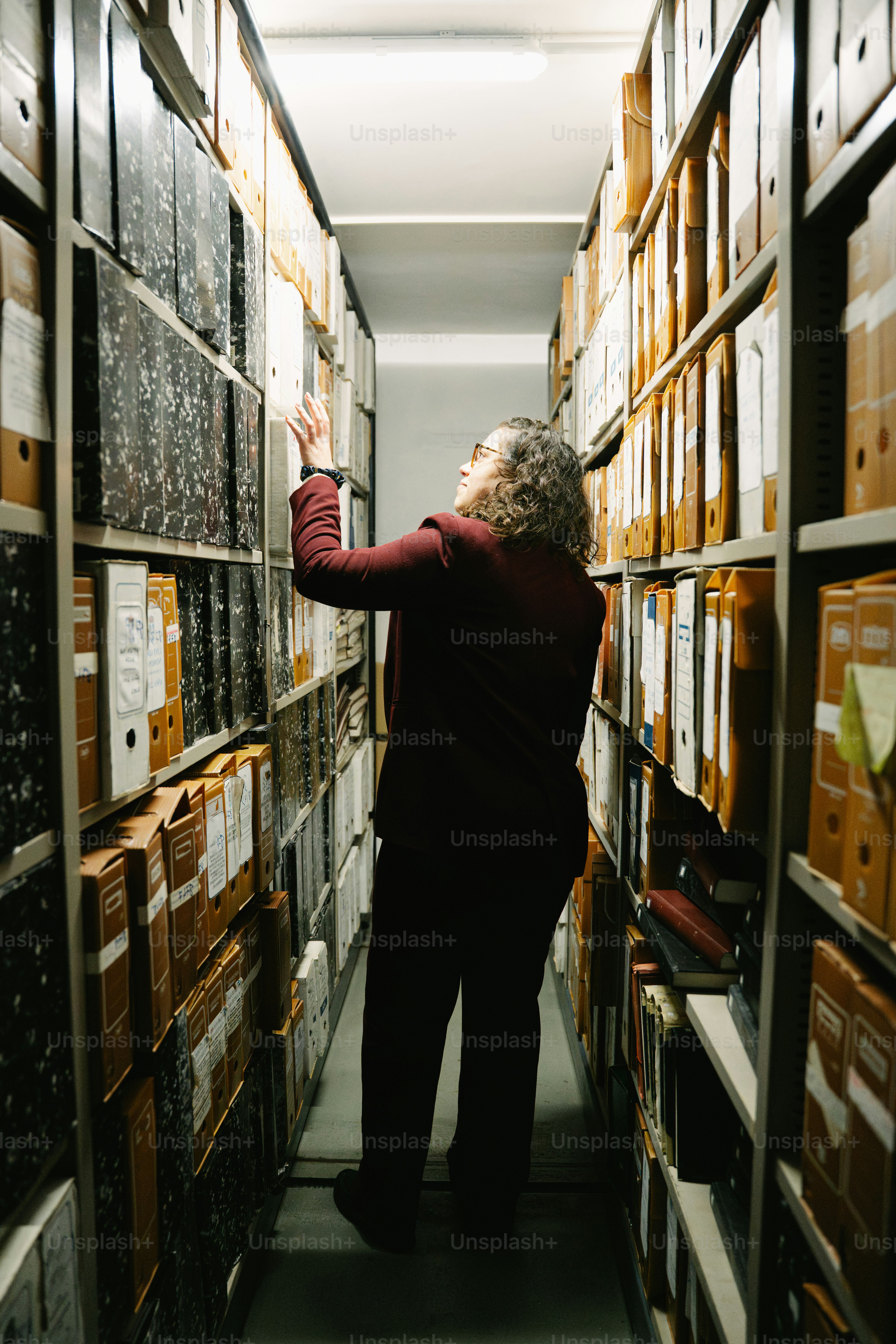 Person searching through rows of archive files