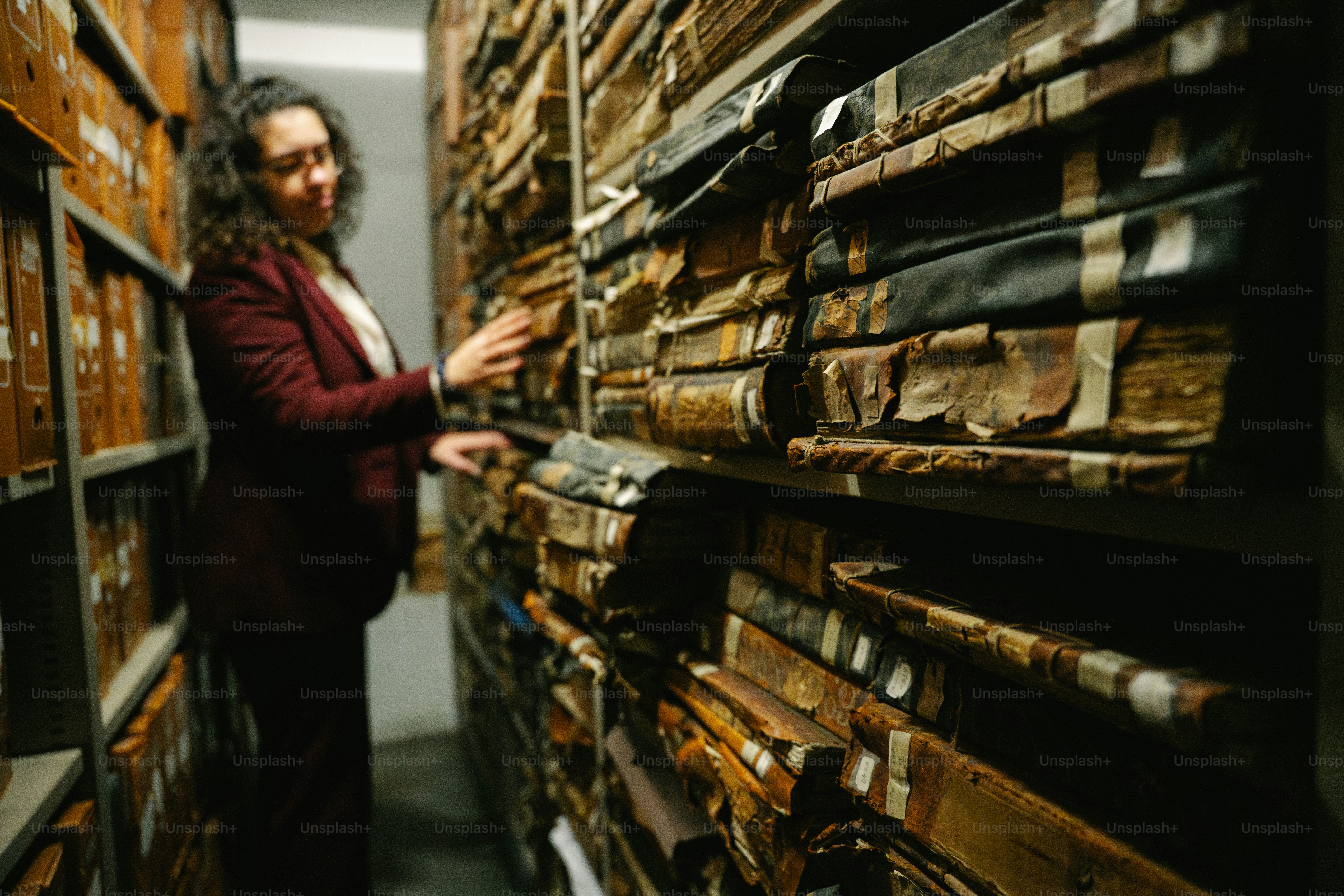Woman browsing ancient files in a library archive.