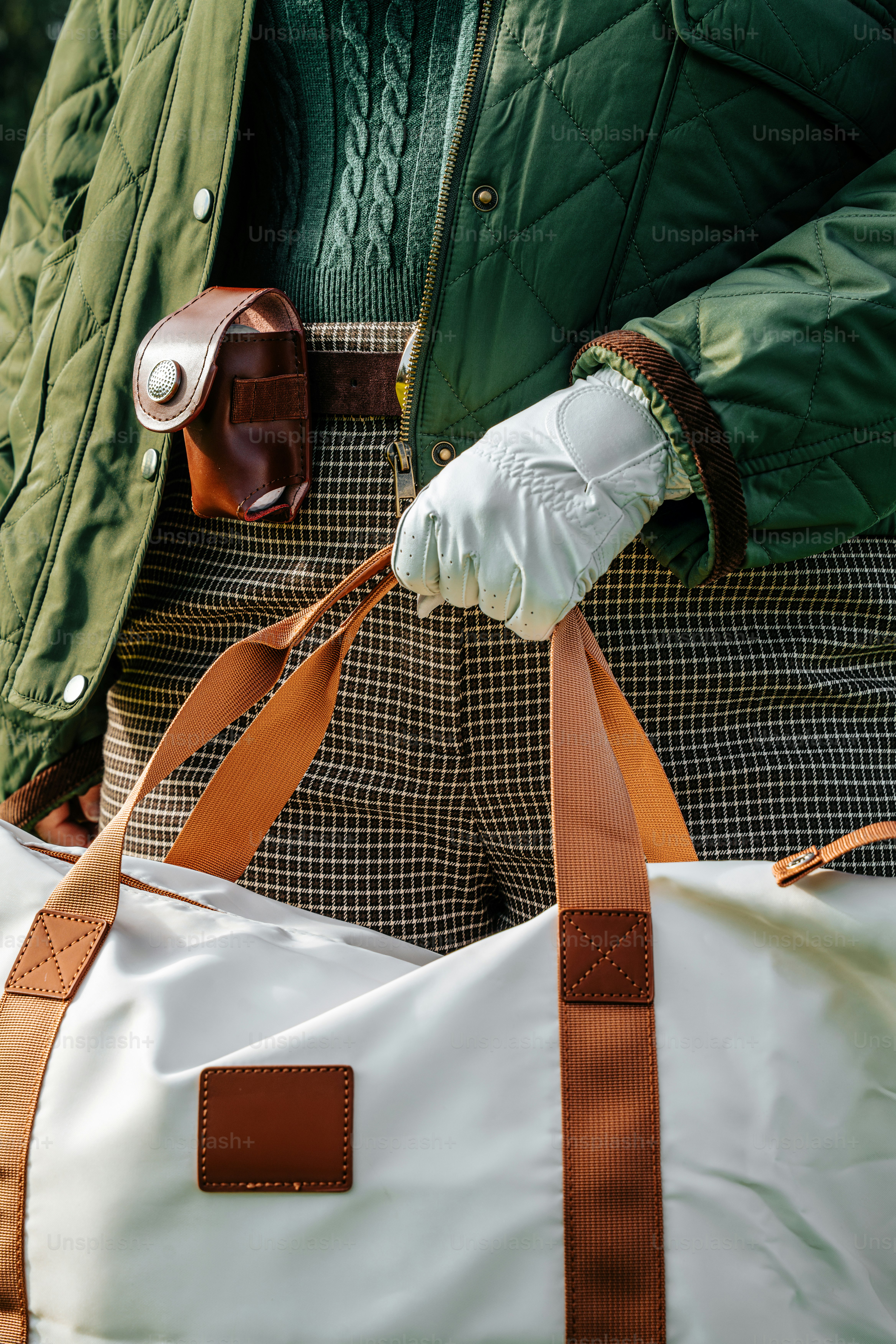 Person in quilted jacket holding a duffel bag