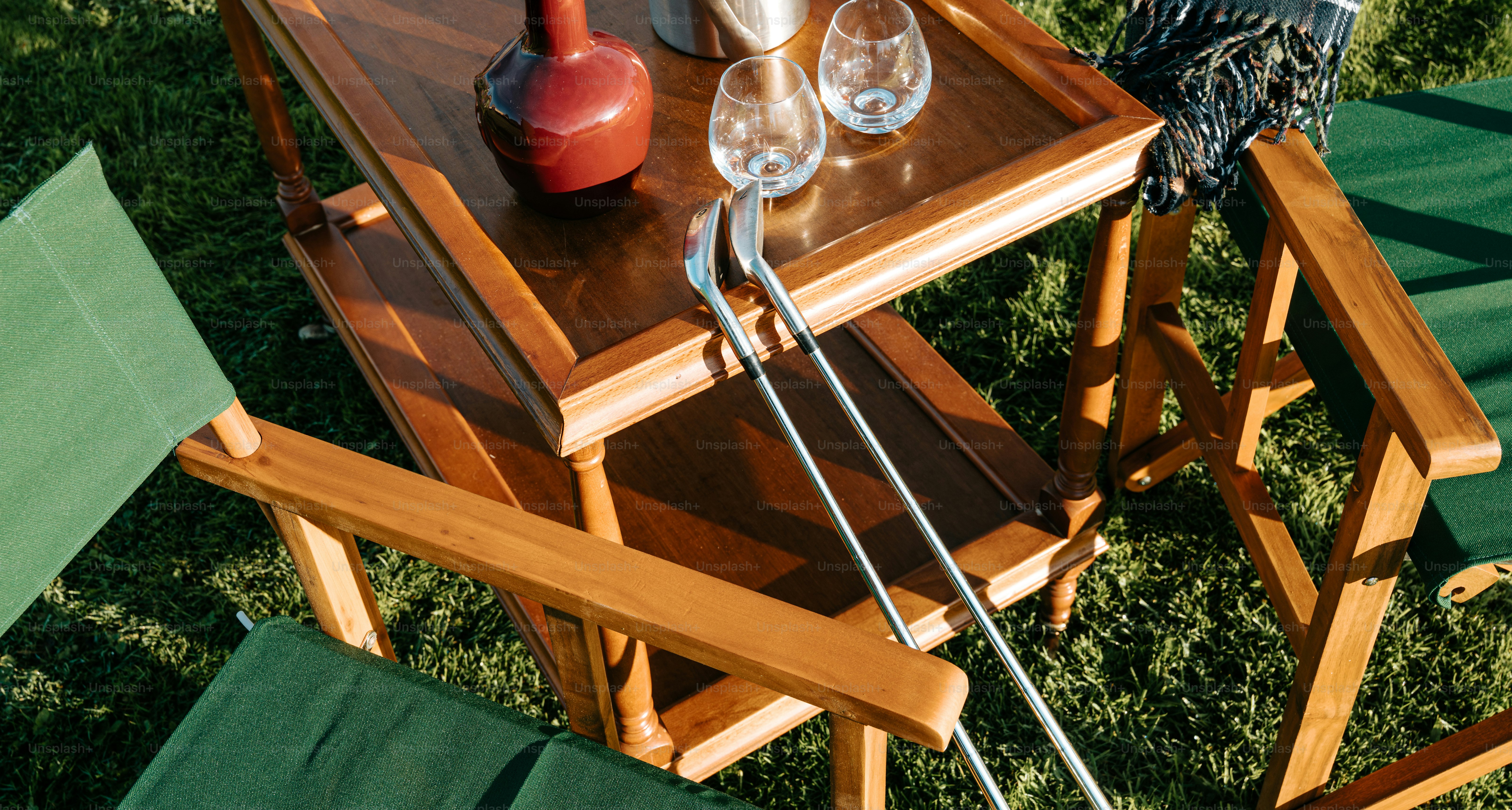 Sedie e tavolo di legno con mazze da golf sull'erba