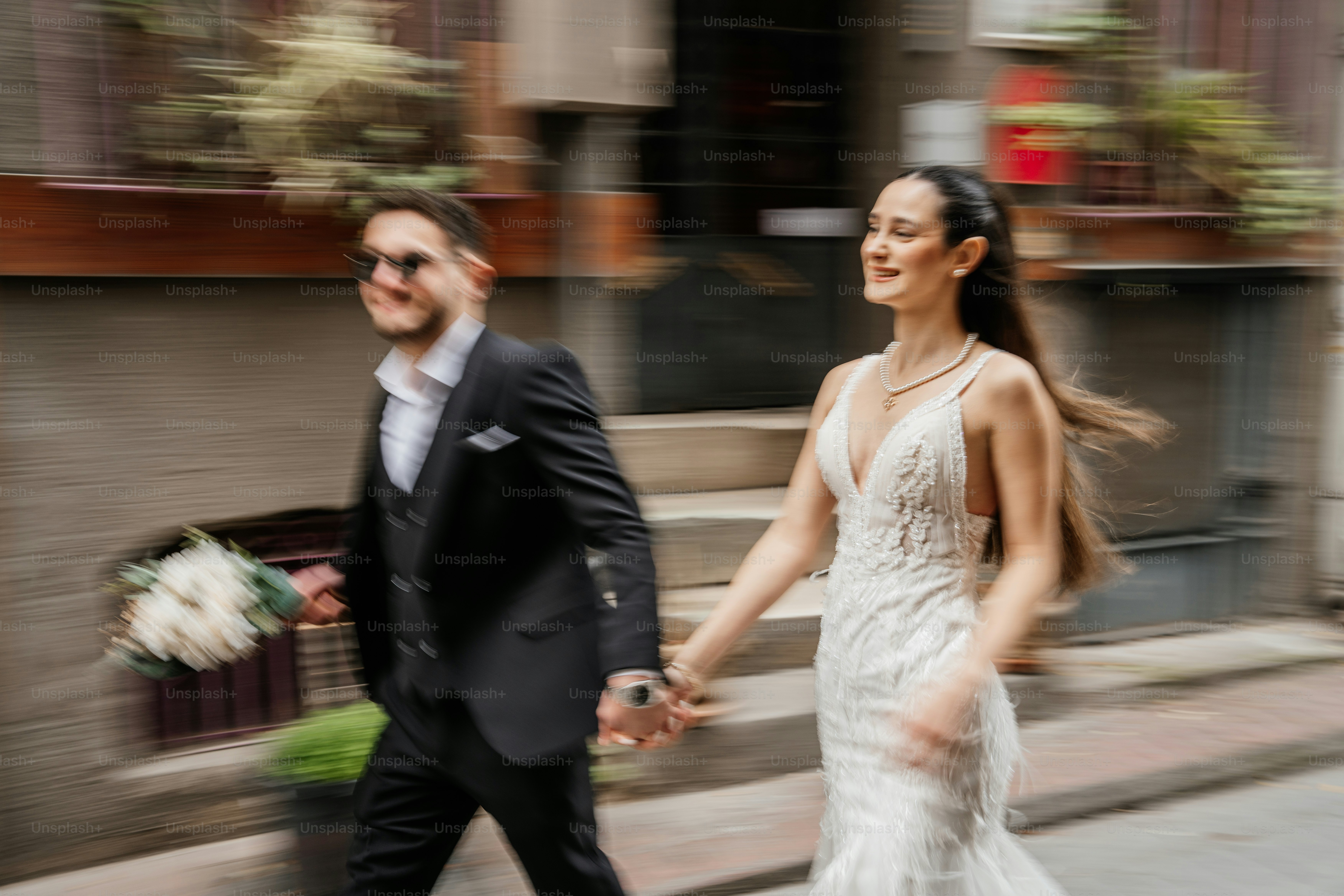 Bride and groom holding hands walking on street