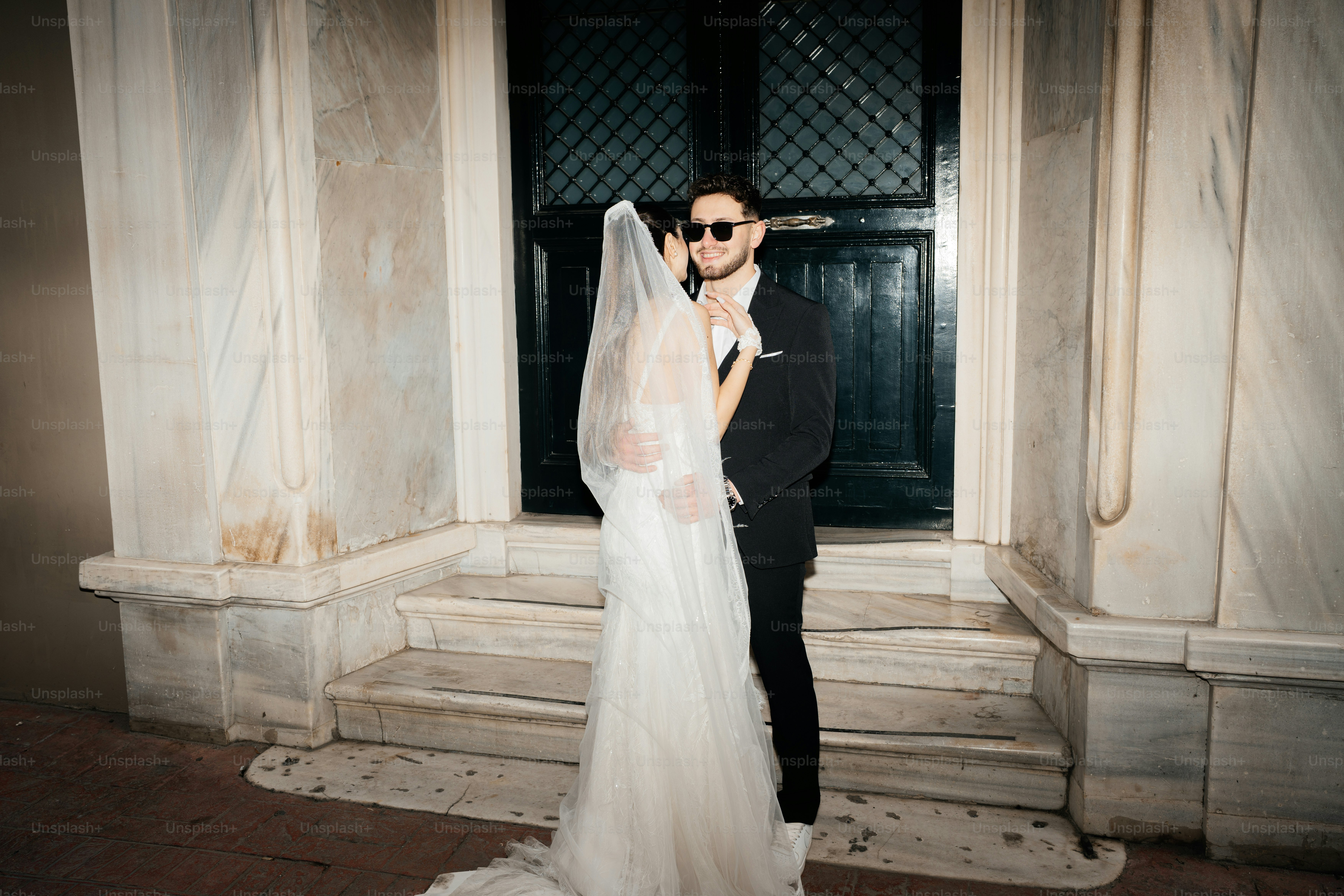Bride and groom embracing in front of a building
