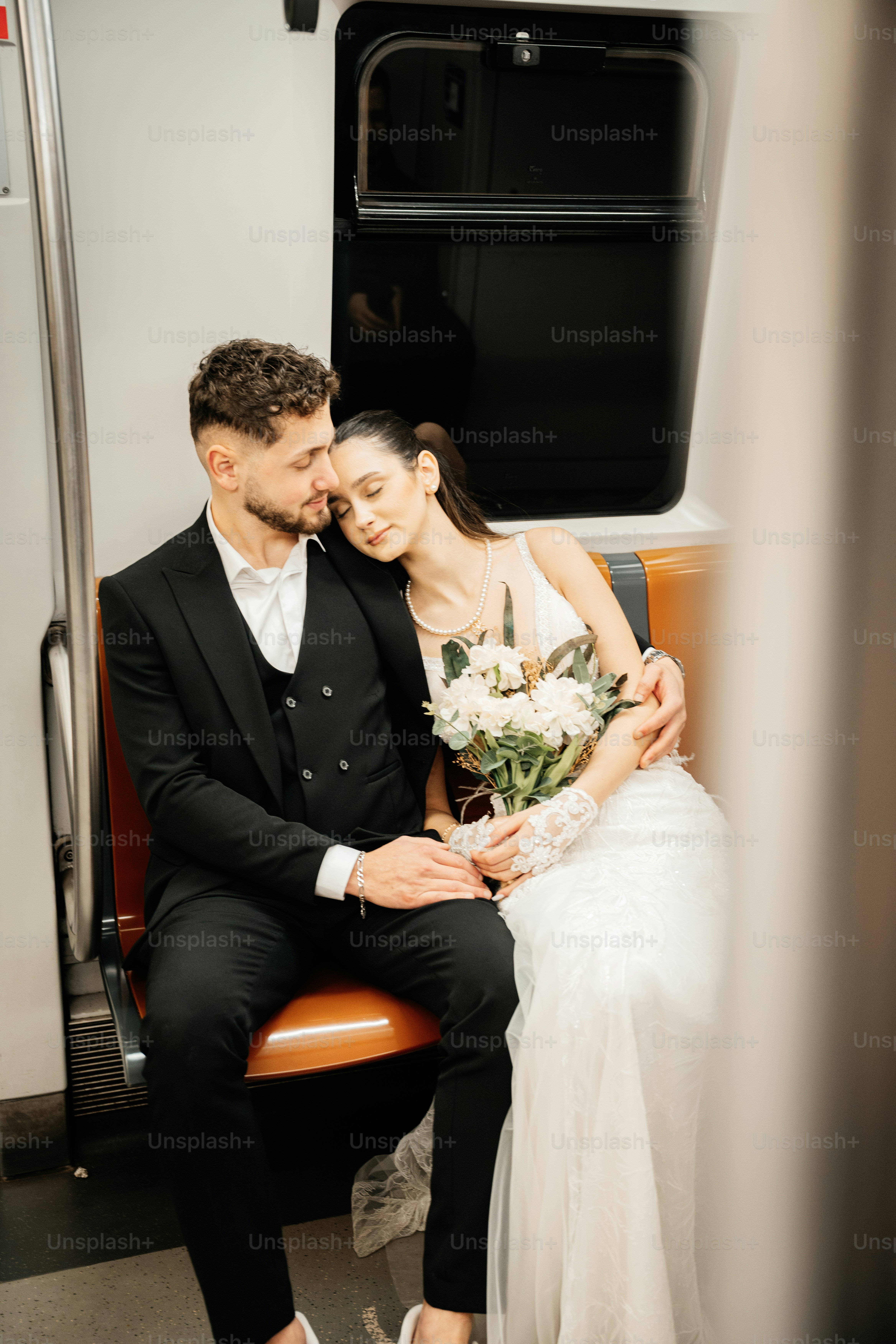 Newlyweds embracing on a subway train