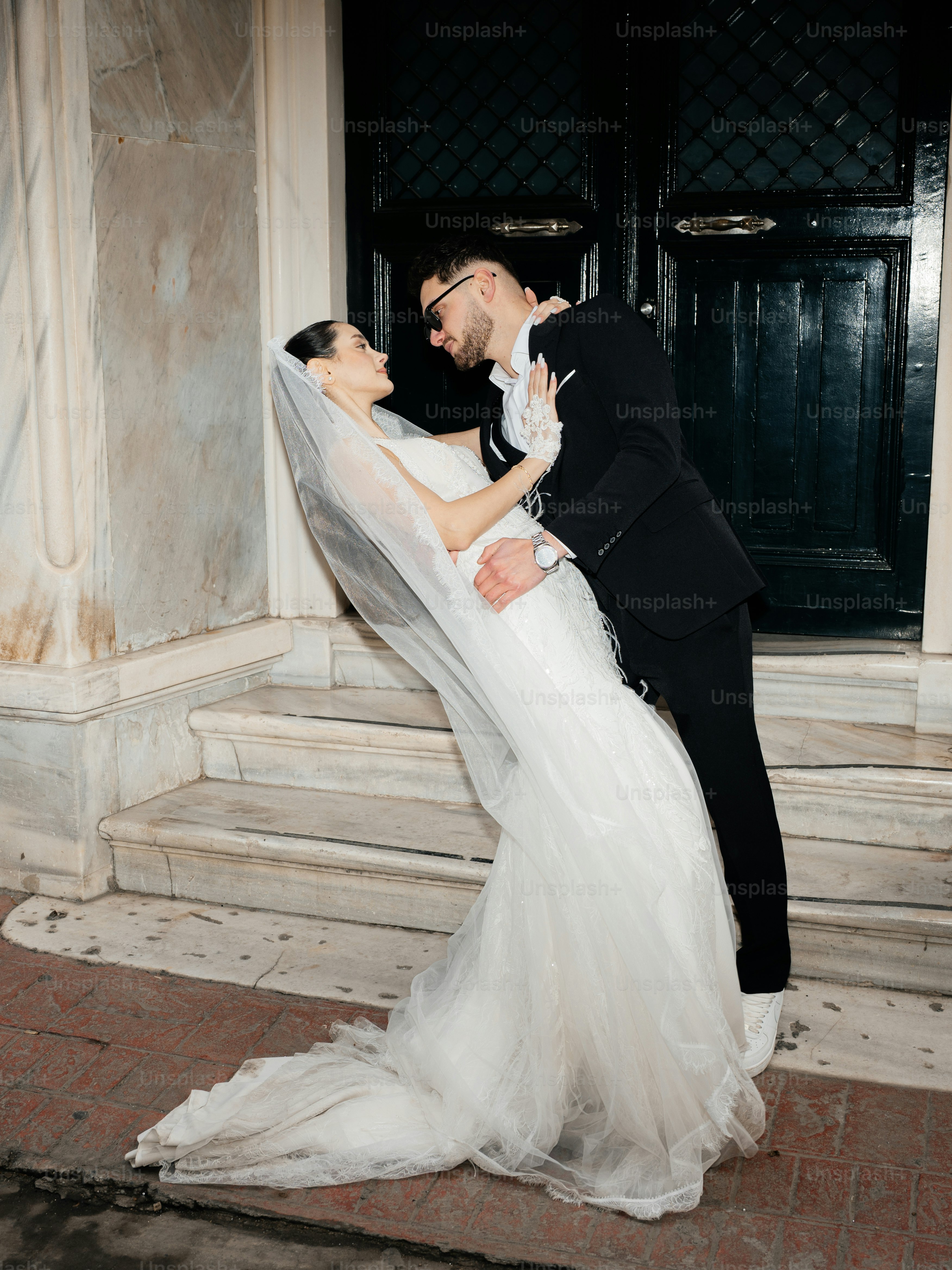 Bride and groom embracing in front of a doorway.