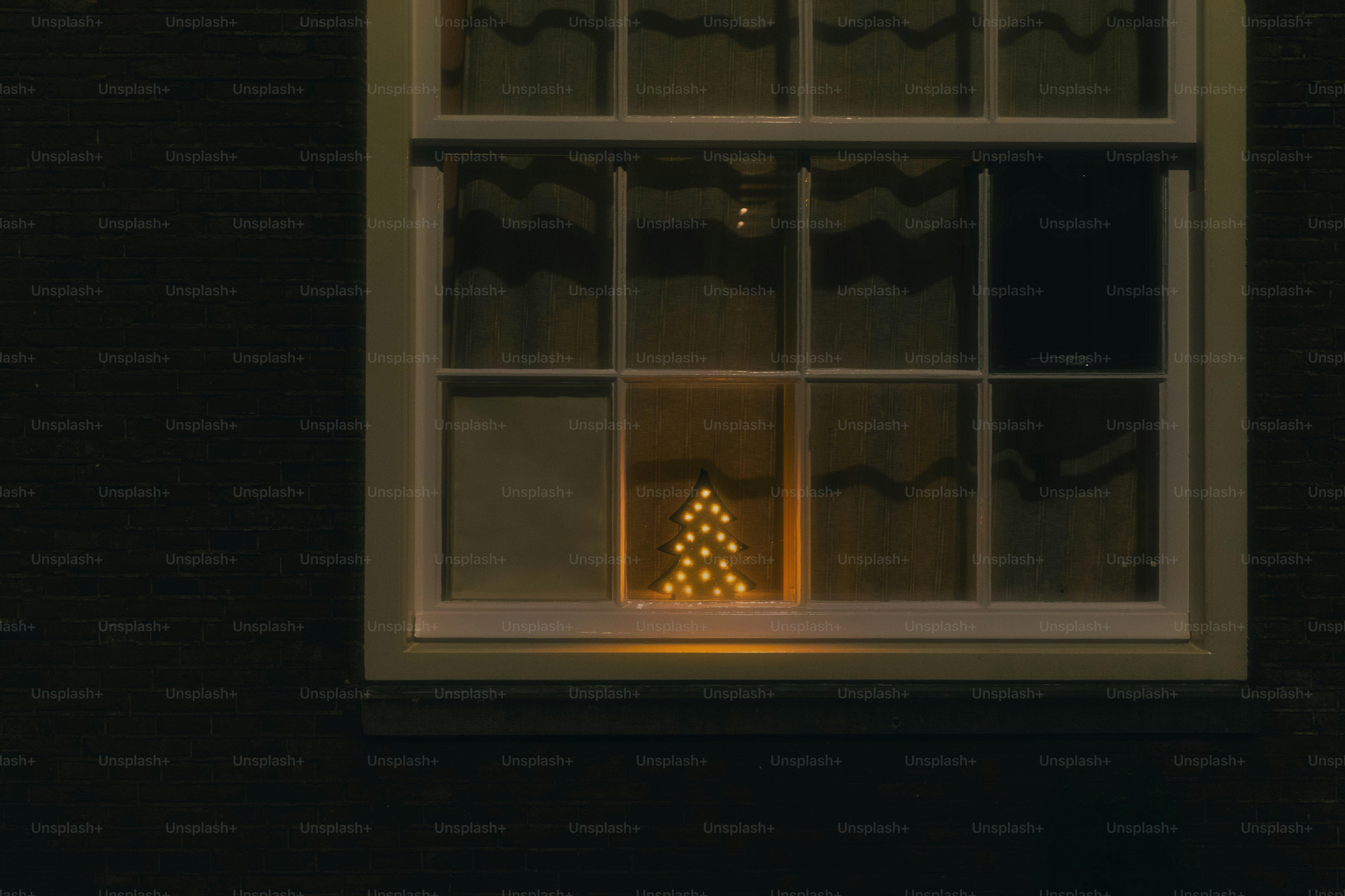 Christmas tree lights glowing in a dark window photo – Christmas Image ...