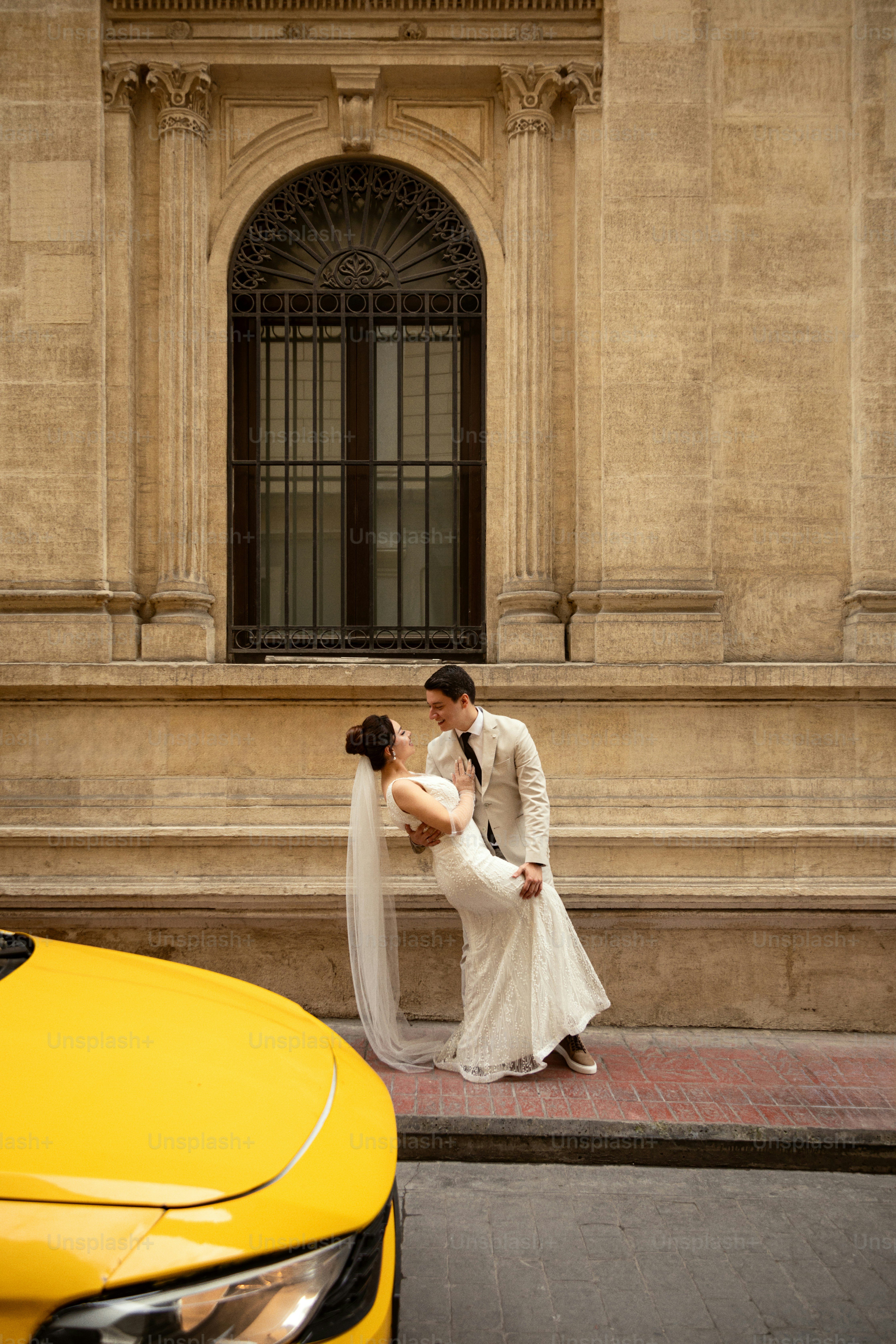 La mariée et le marié dansent dans la voiture jaune