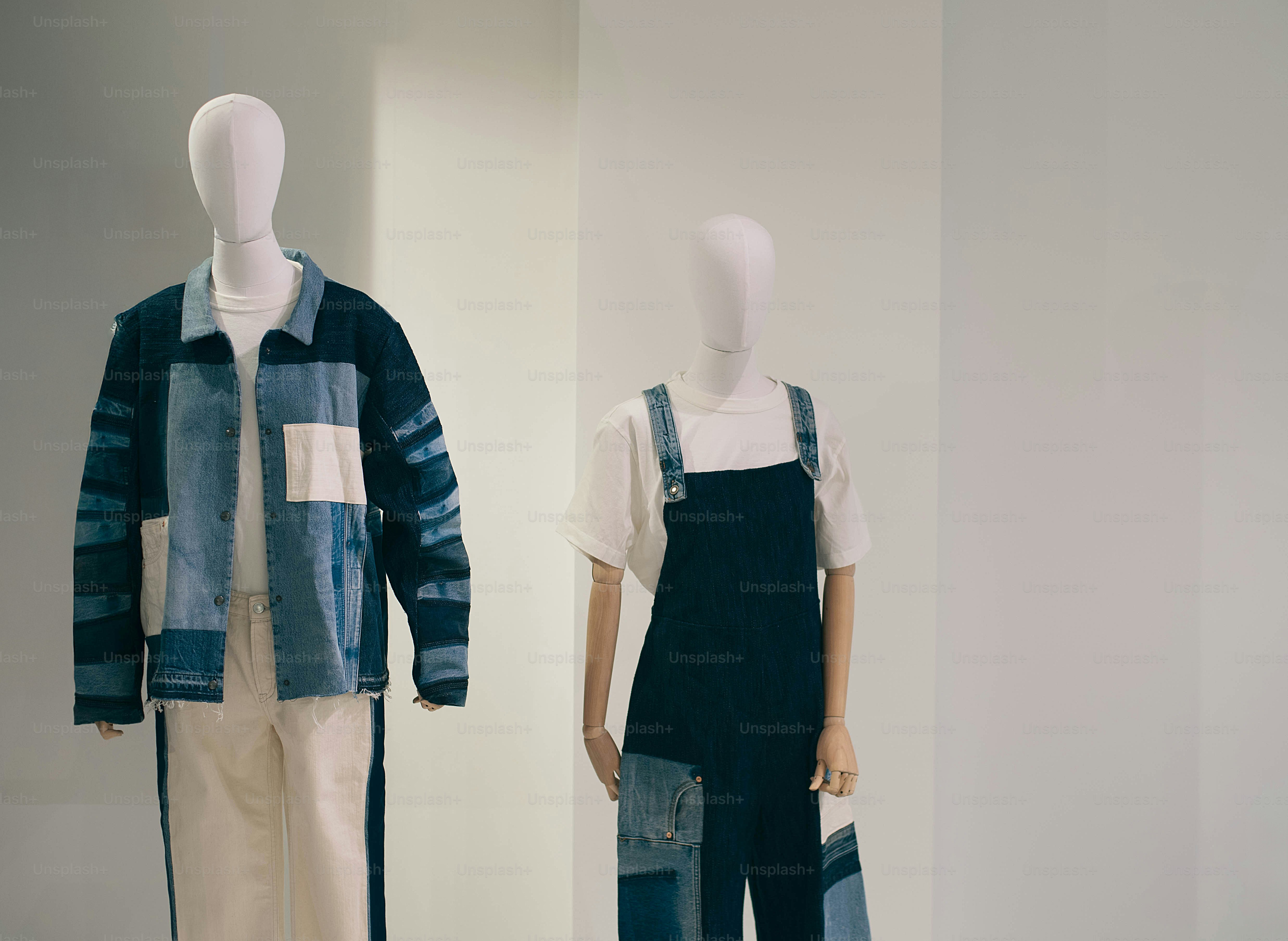 Two mannequins display denim patchwork outfits.