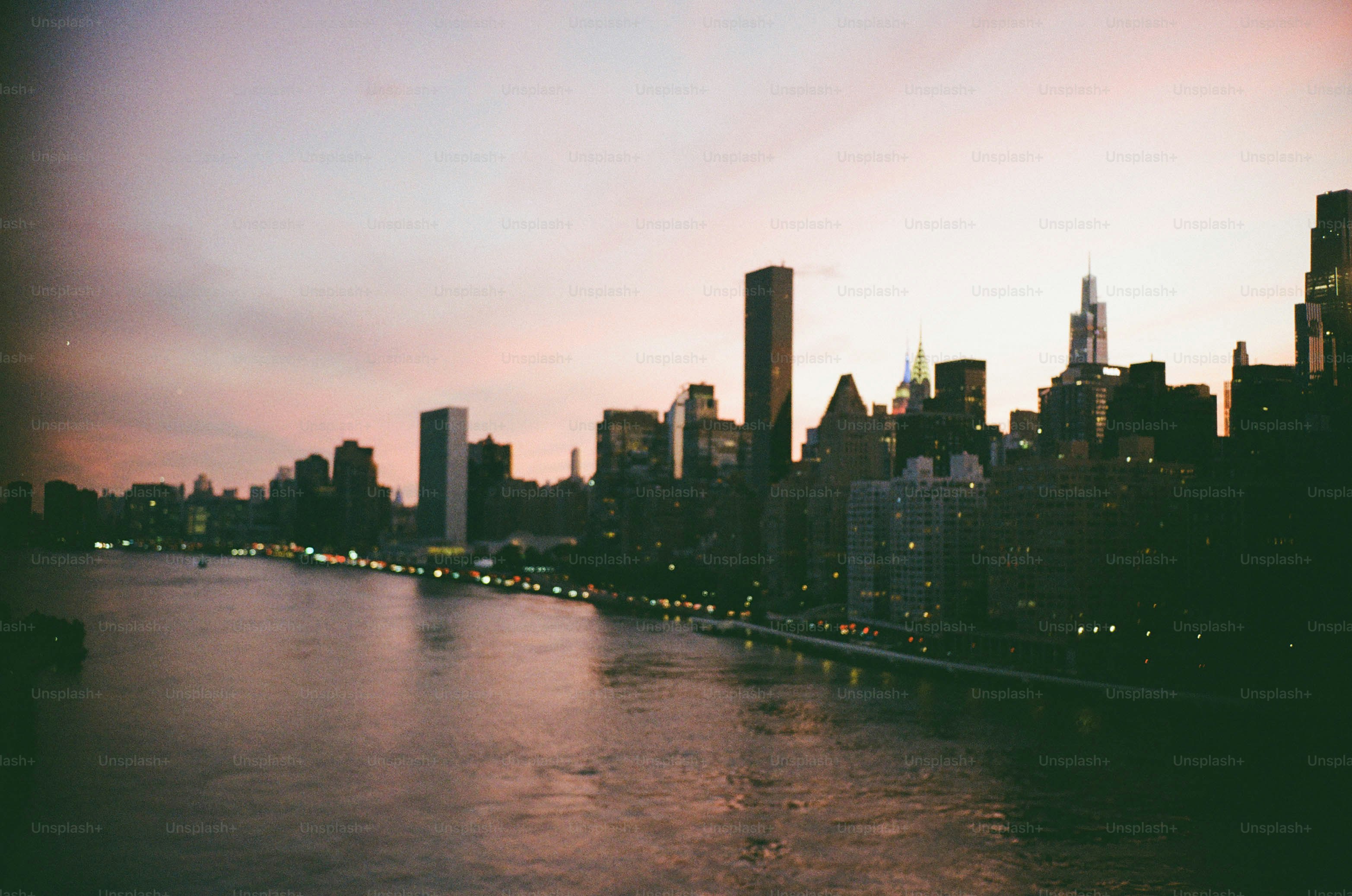 City skyline at dusk with river and lights