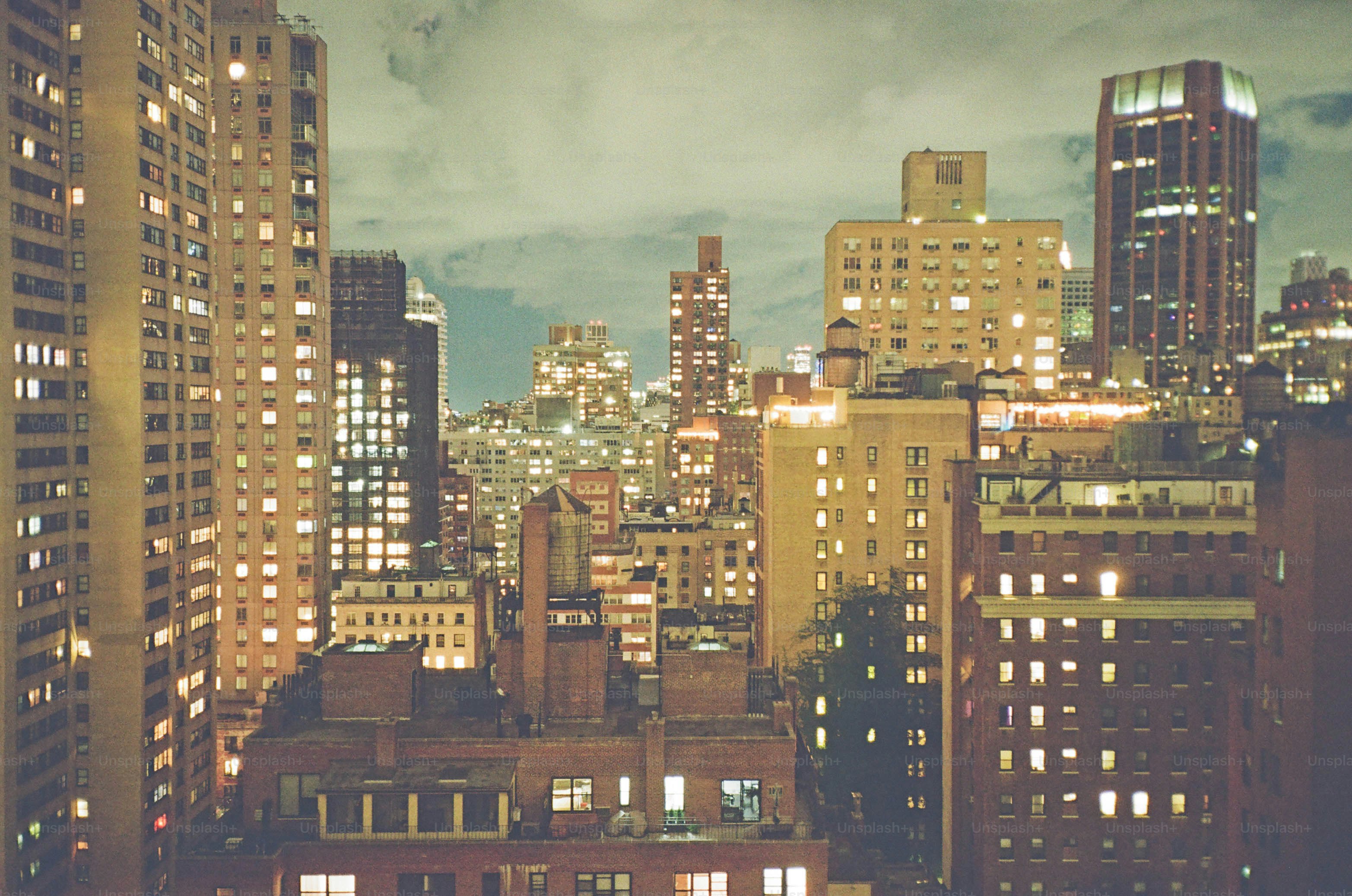 夕暮れ時の明かりに照らされた高層ビル、曇り空。