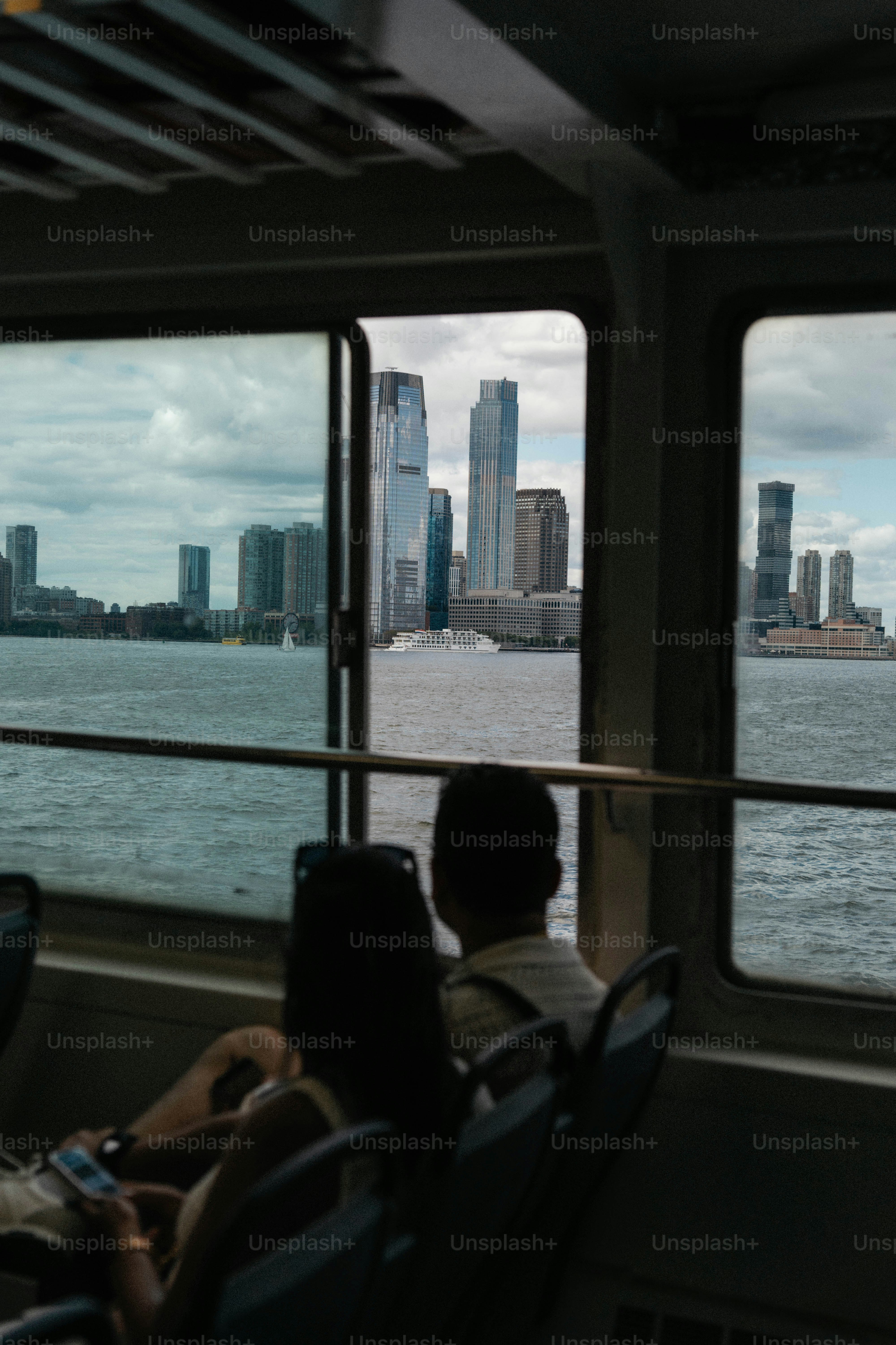 Two people look out at city skyline from ferry