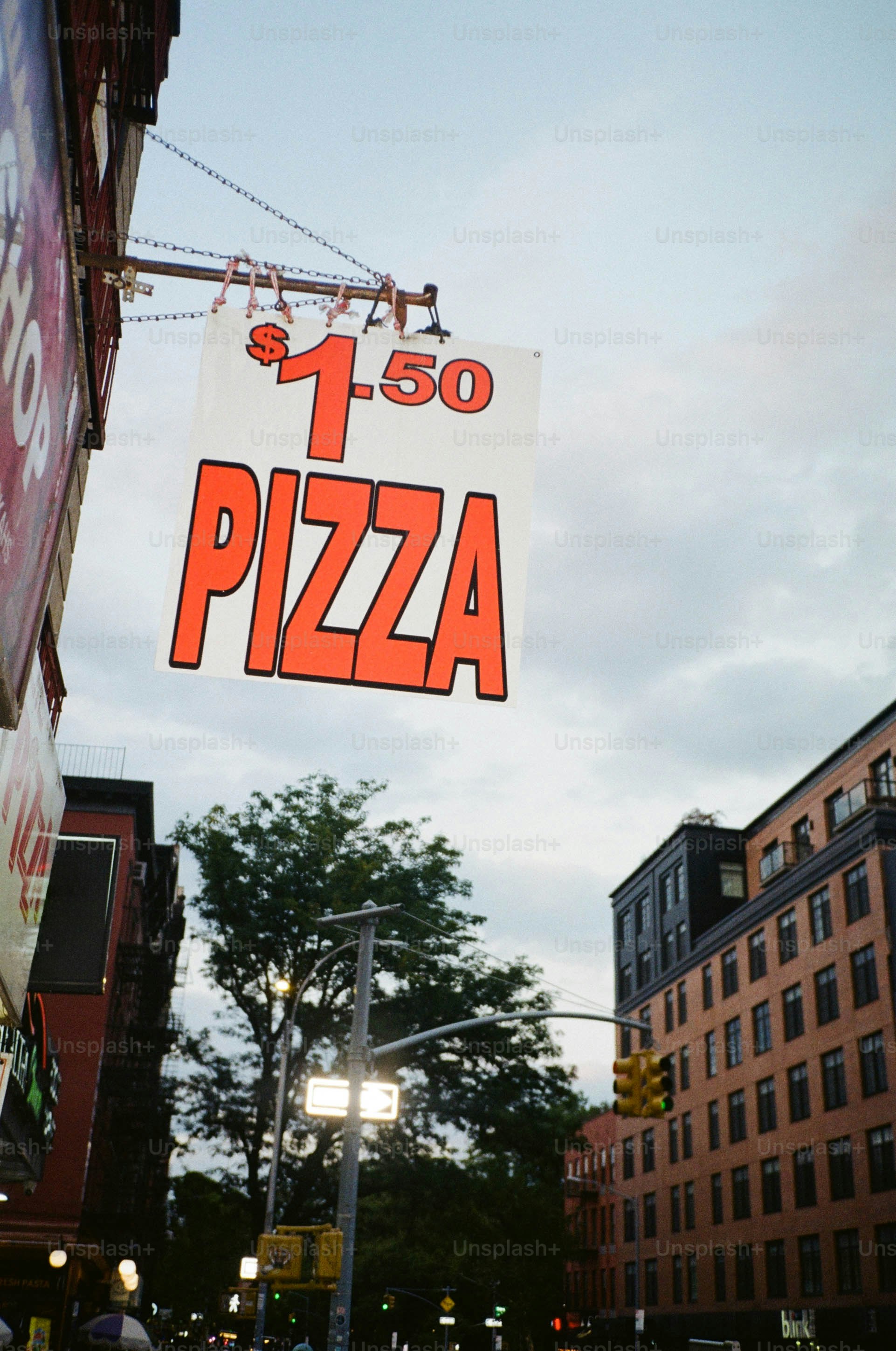 $1.50 pizza sign hanging outside shop