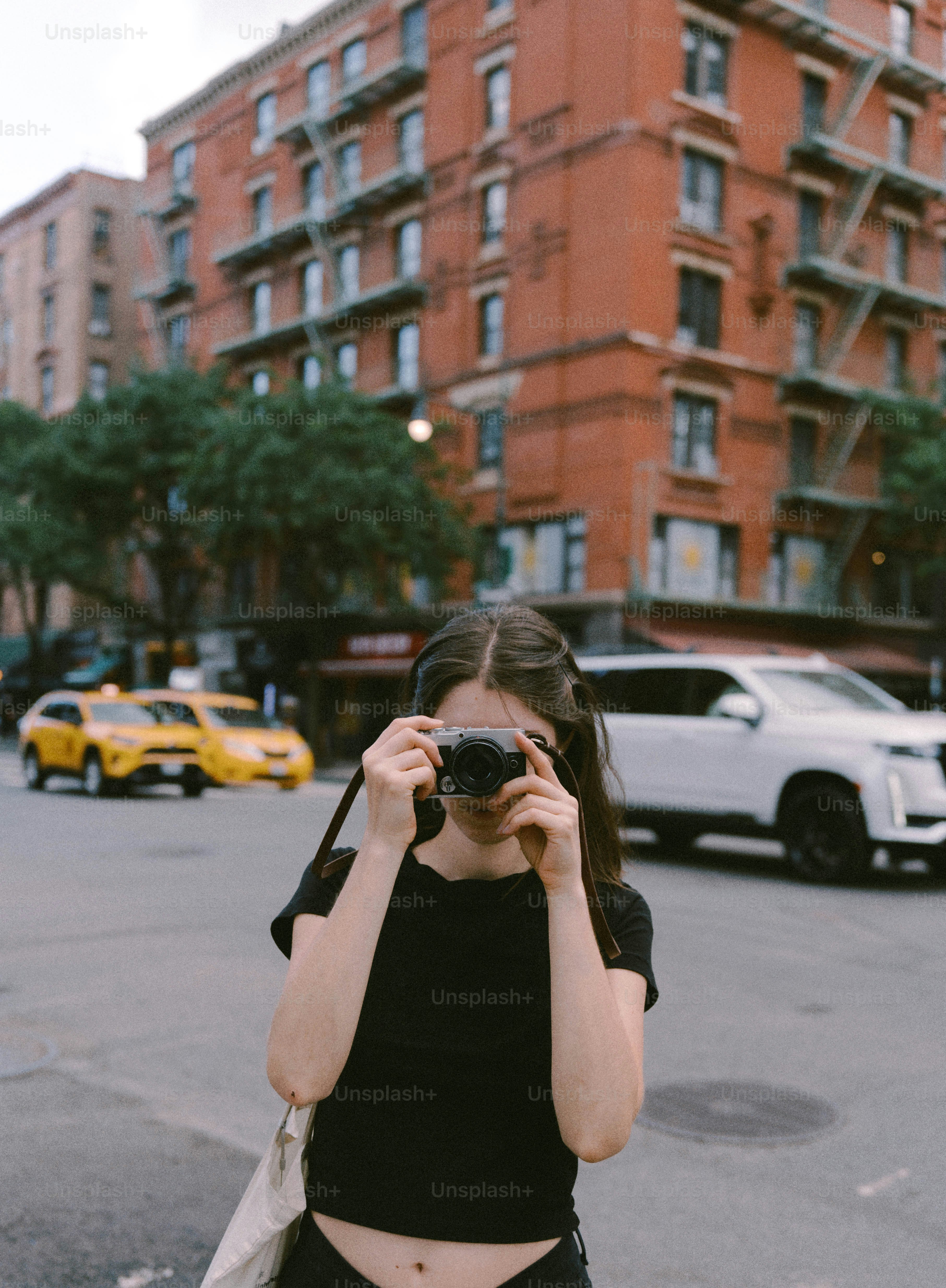 通りでカメラで写真を撮る女性