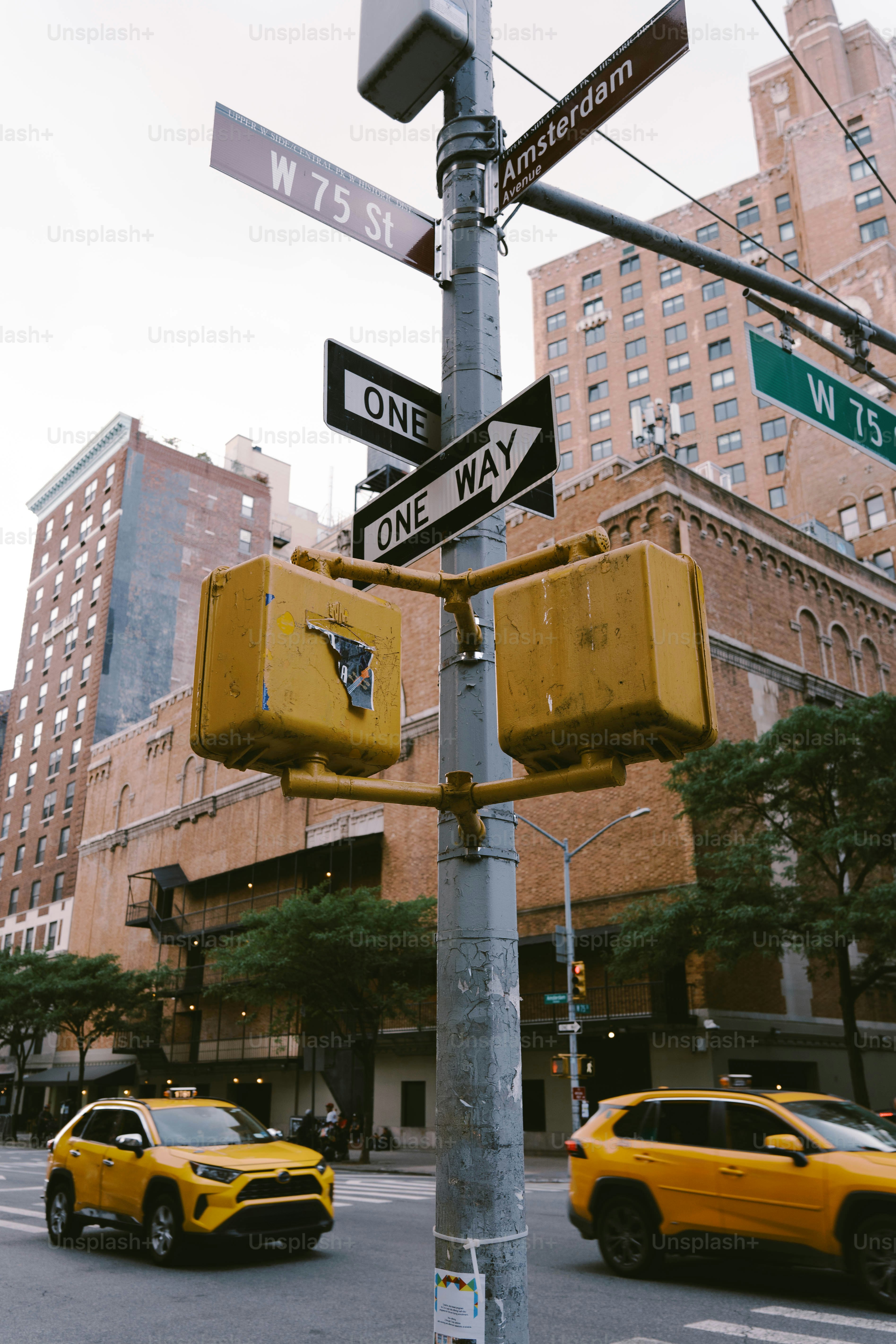 信号のある街の通りを黄色いタクシーで走っています。