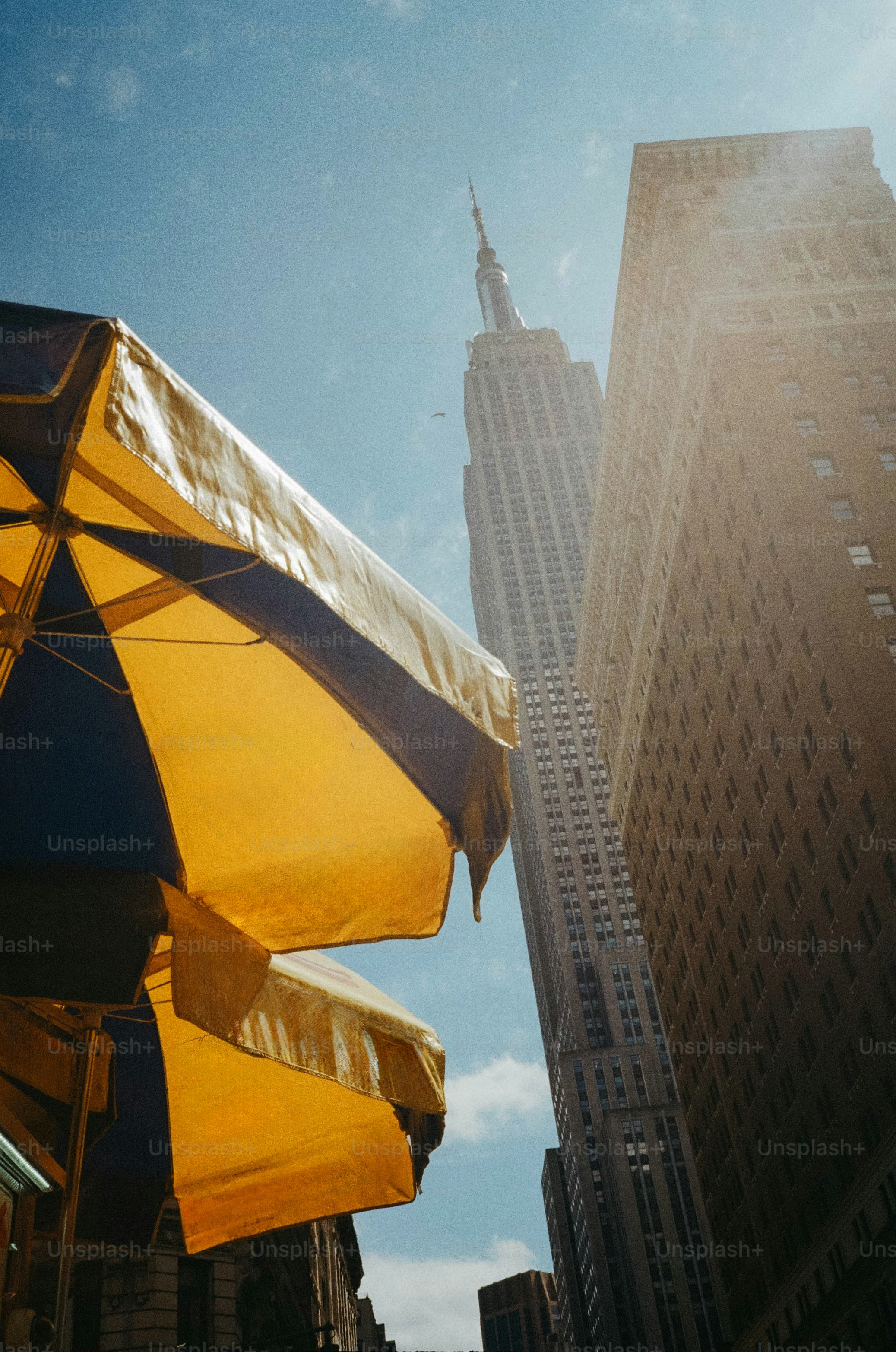 Empire state building seen from below with yellow umbrella