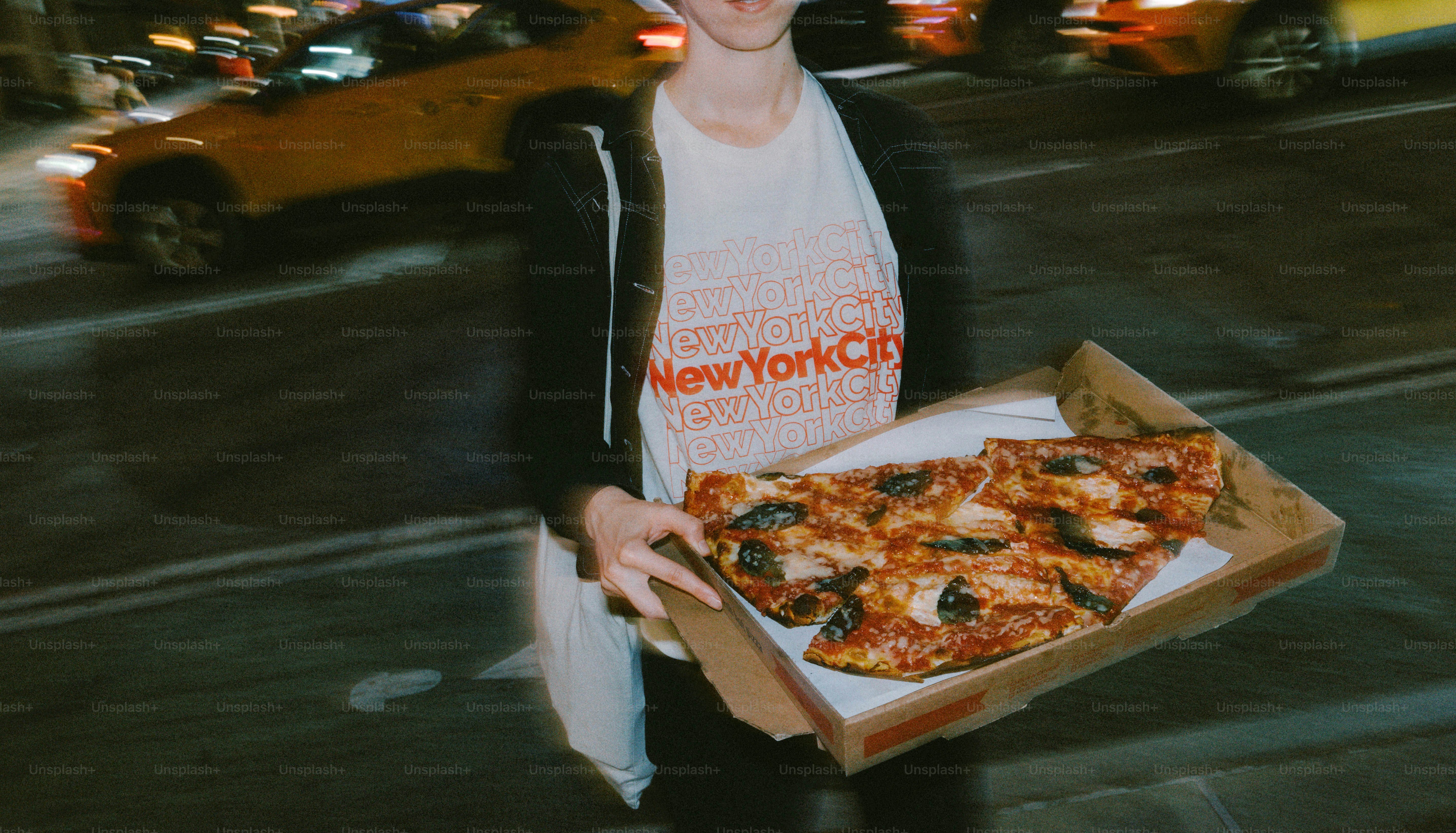 街の通りでピザの箱を持っている人