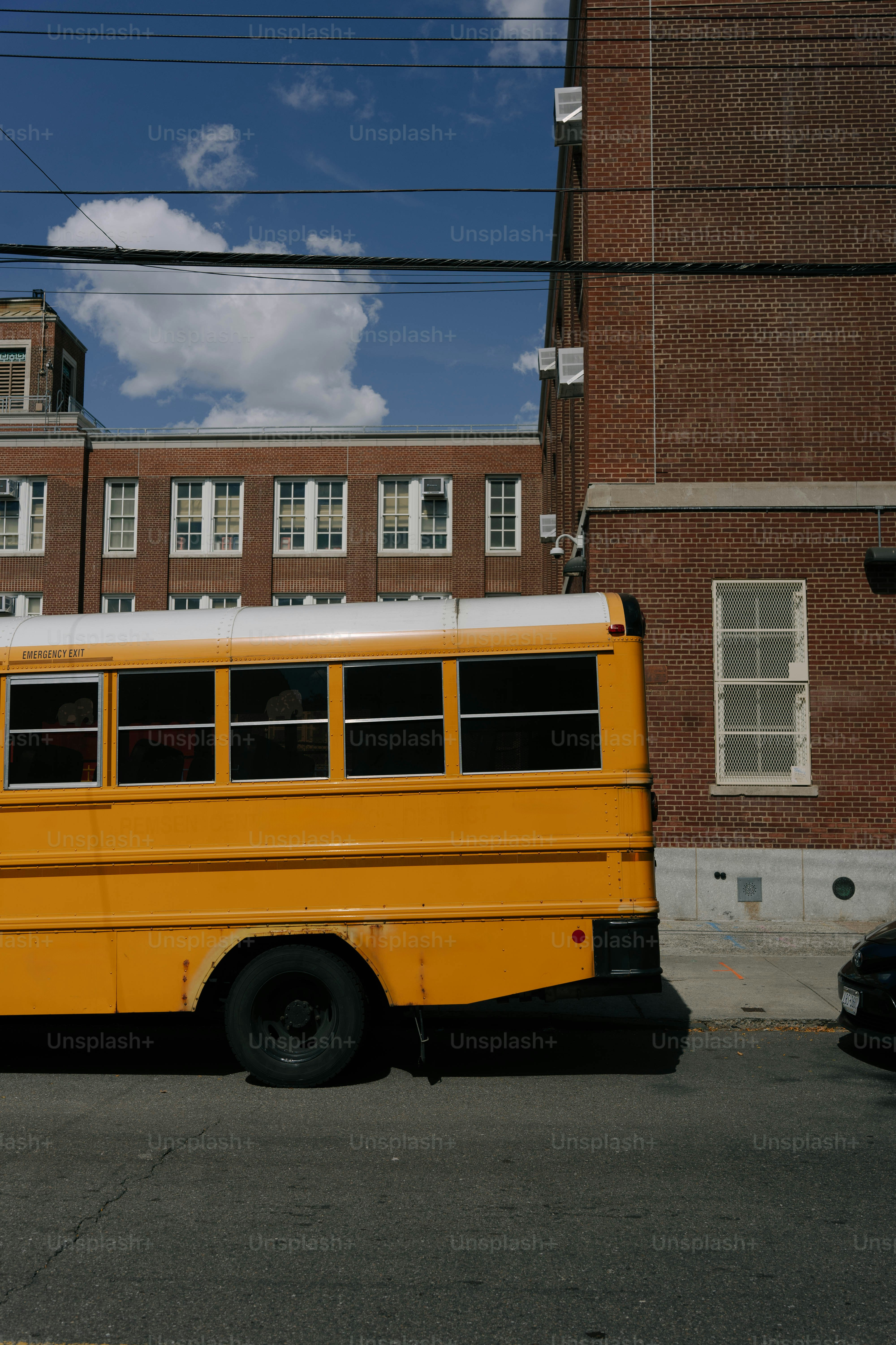 レンガ造りの建物のそばに停められた黄色いスクールバス