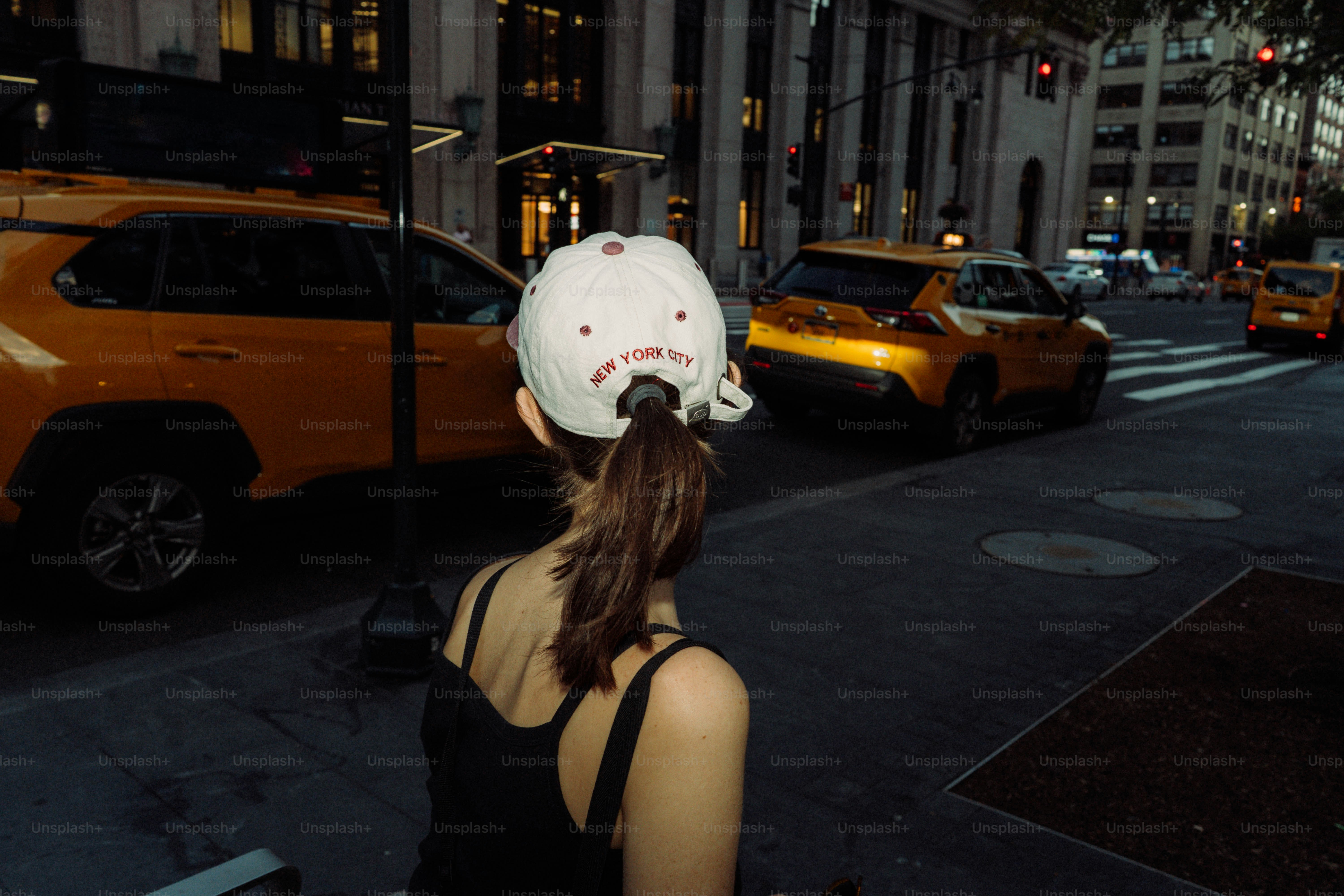 Woman in baseball cap on city street at night photo – Travel Image on ...