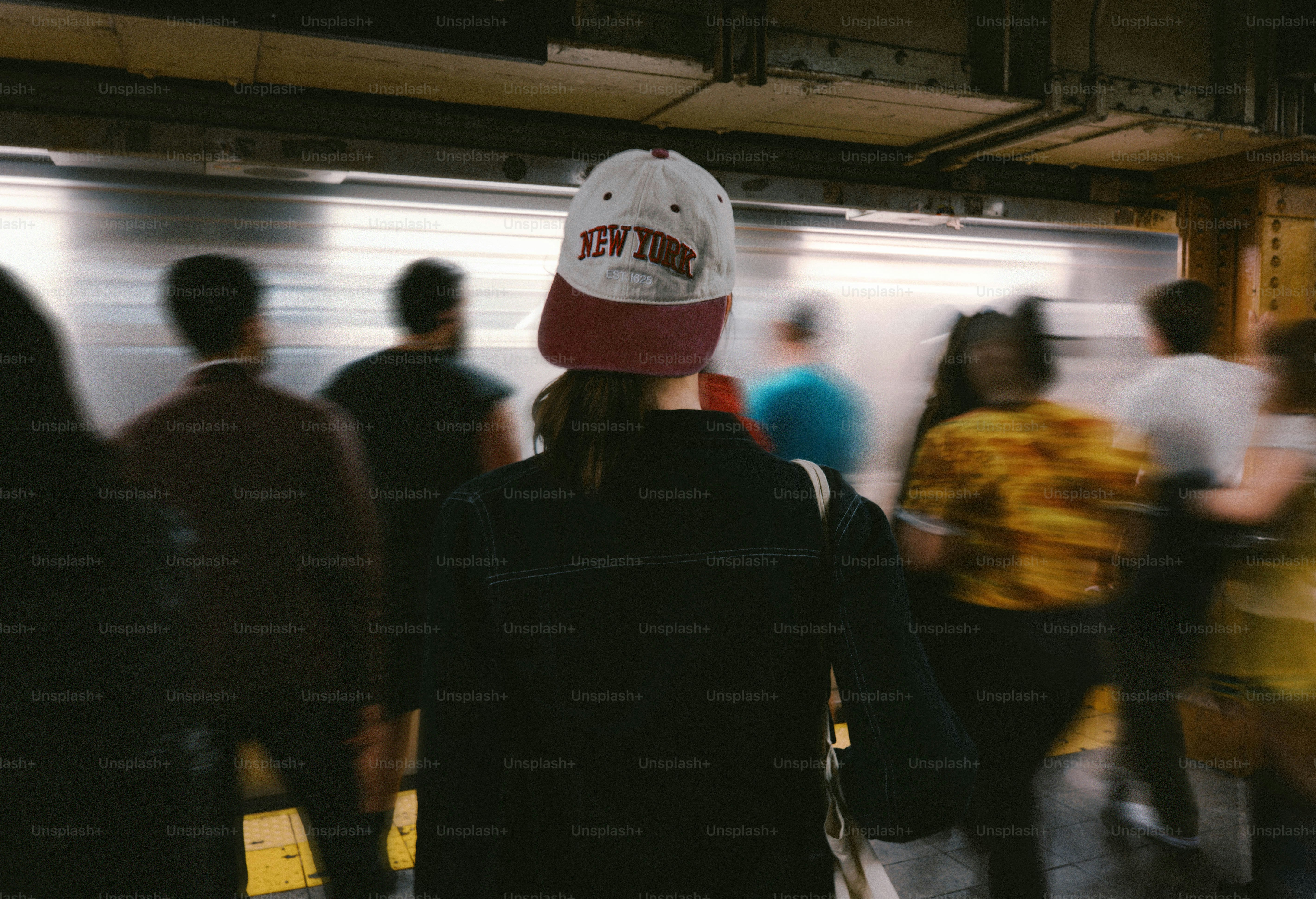 地下鉄を待つ人々と、ぼやけた電車が通り過ぎる。