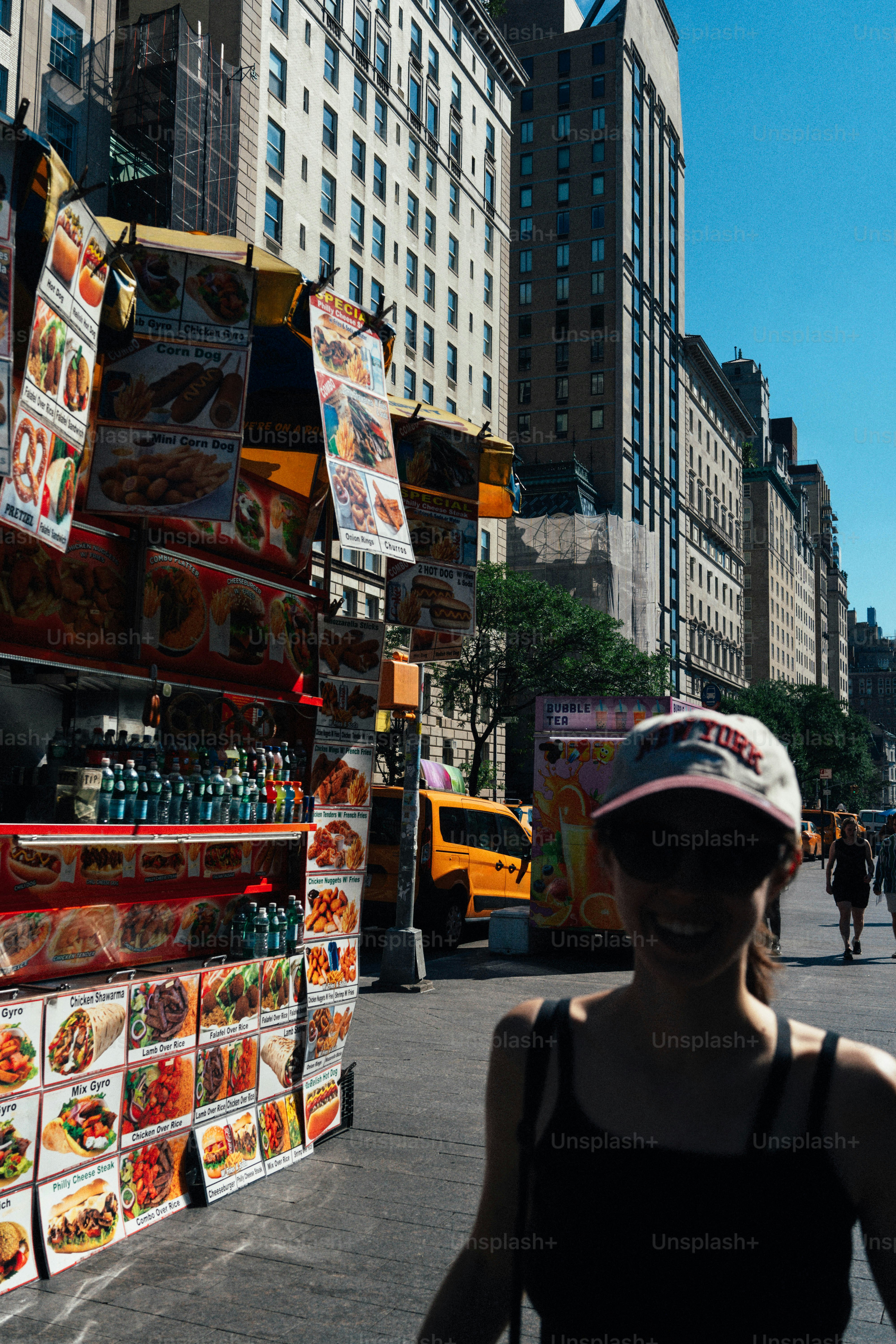 Woman smiles near a new york city food cart.