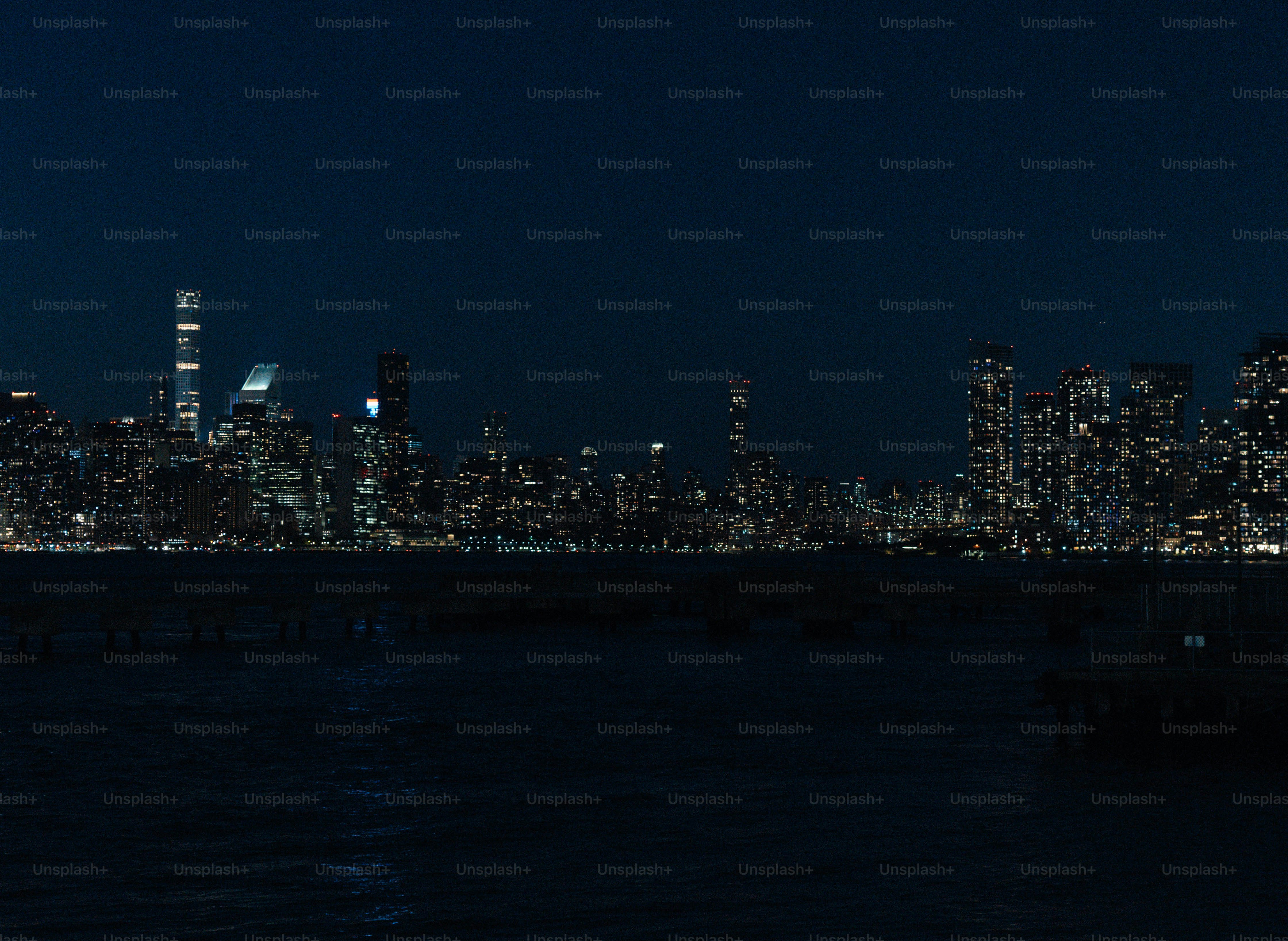 City skyline illuminated at night across the water