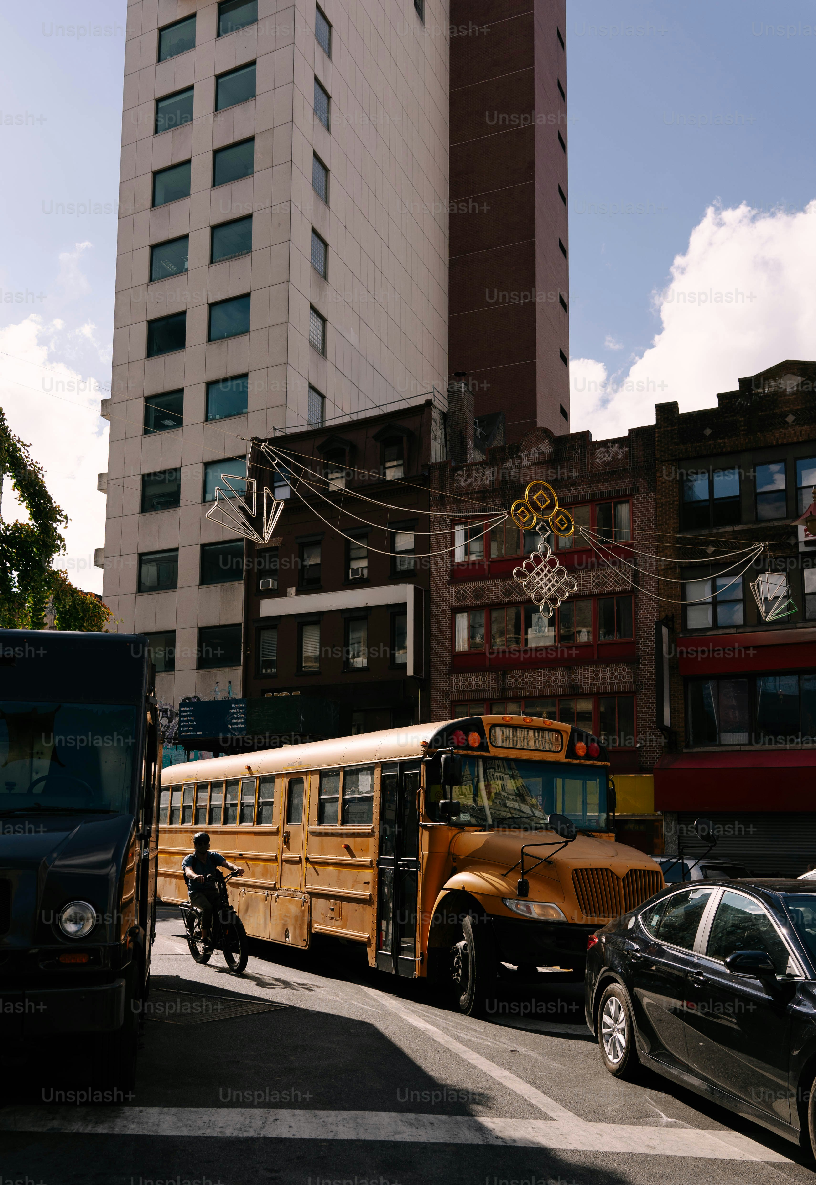 Yellow school bus on a city street with buildings.
