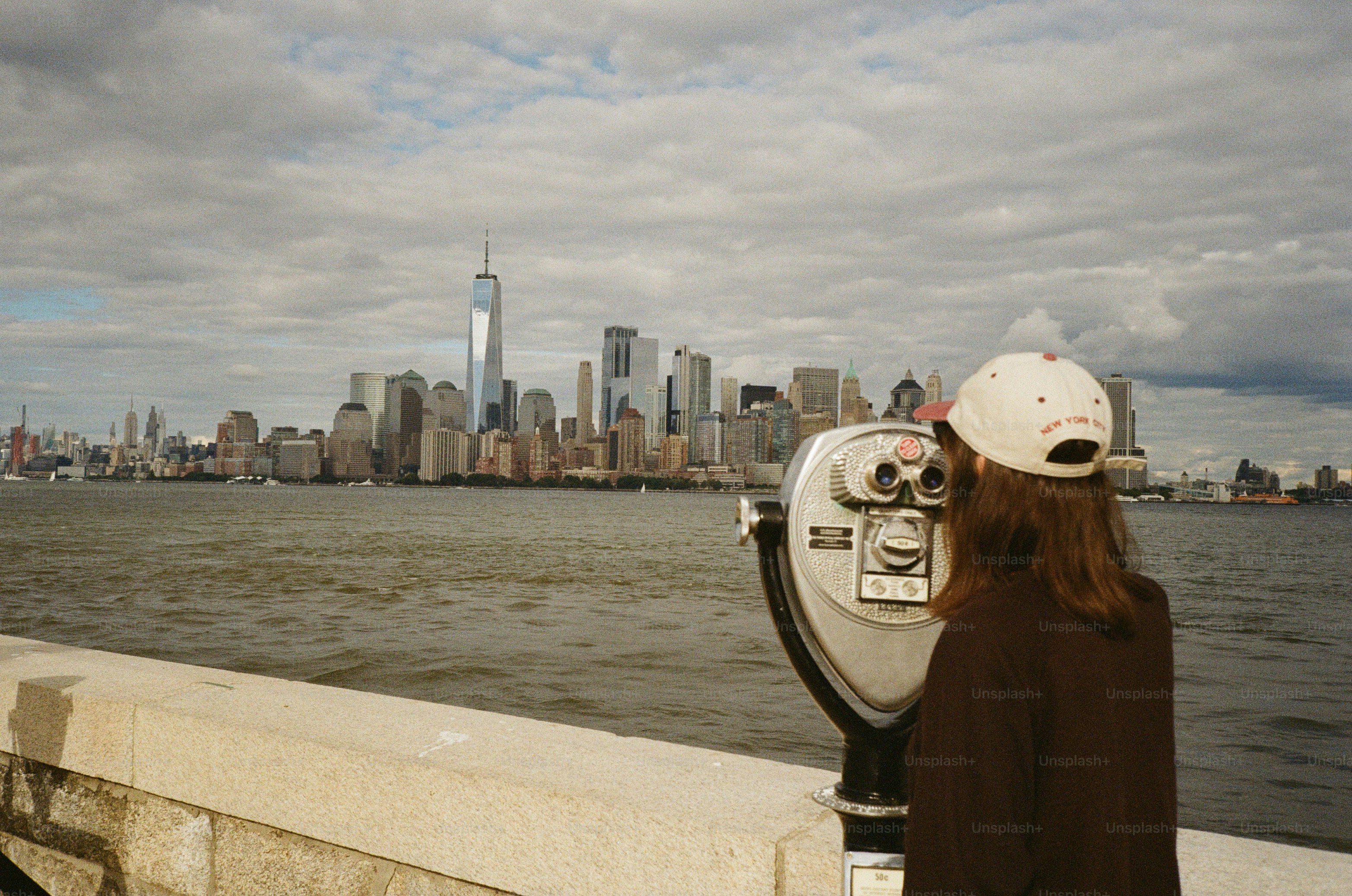 Woman looking at new york city skyline through binoculars.