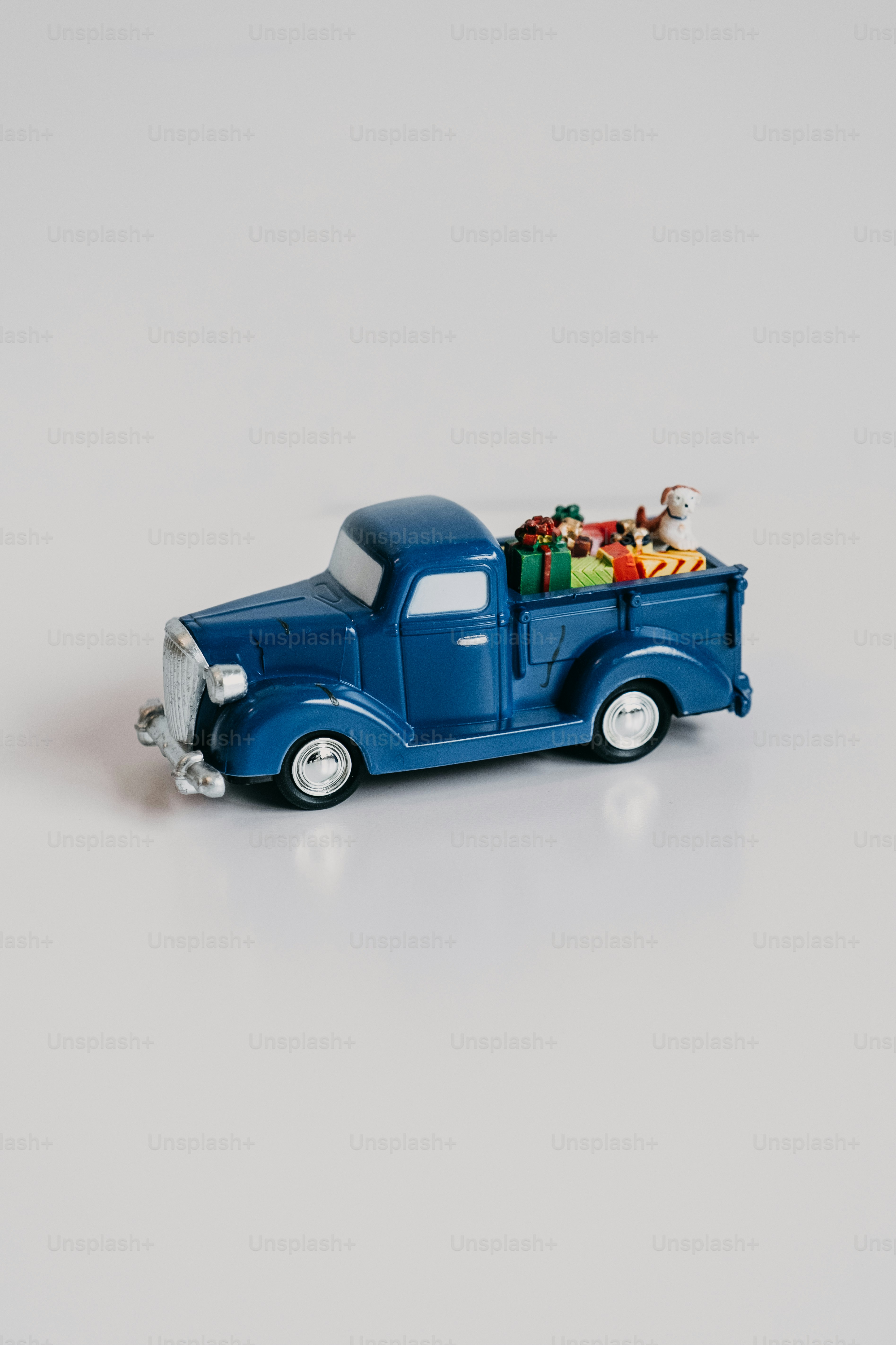 Blue vintage truck carrying colorful christmas presents