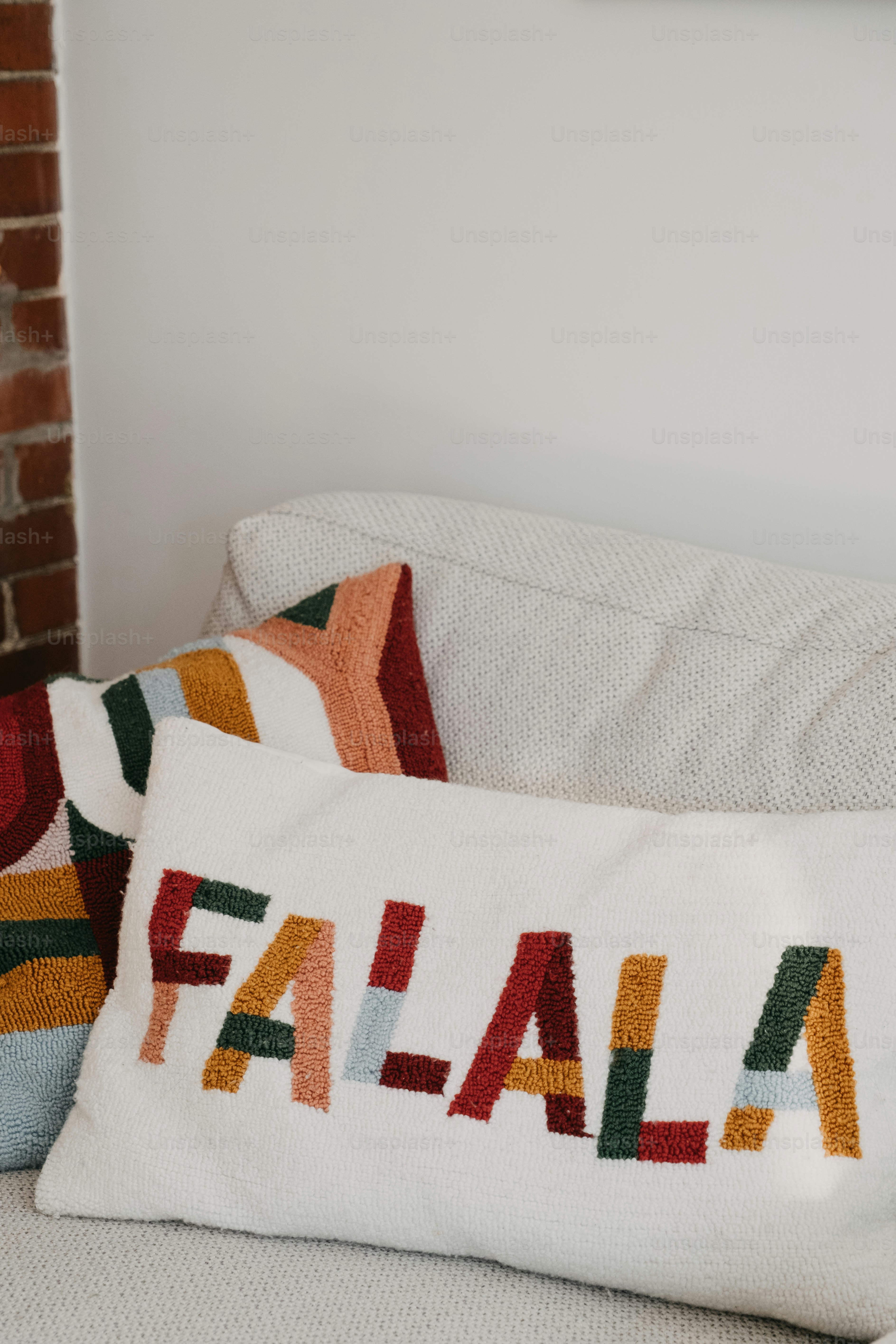 Pillows with "falala" text on a sofa