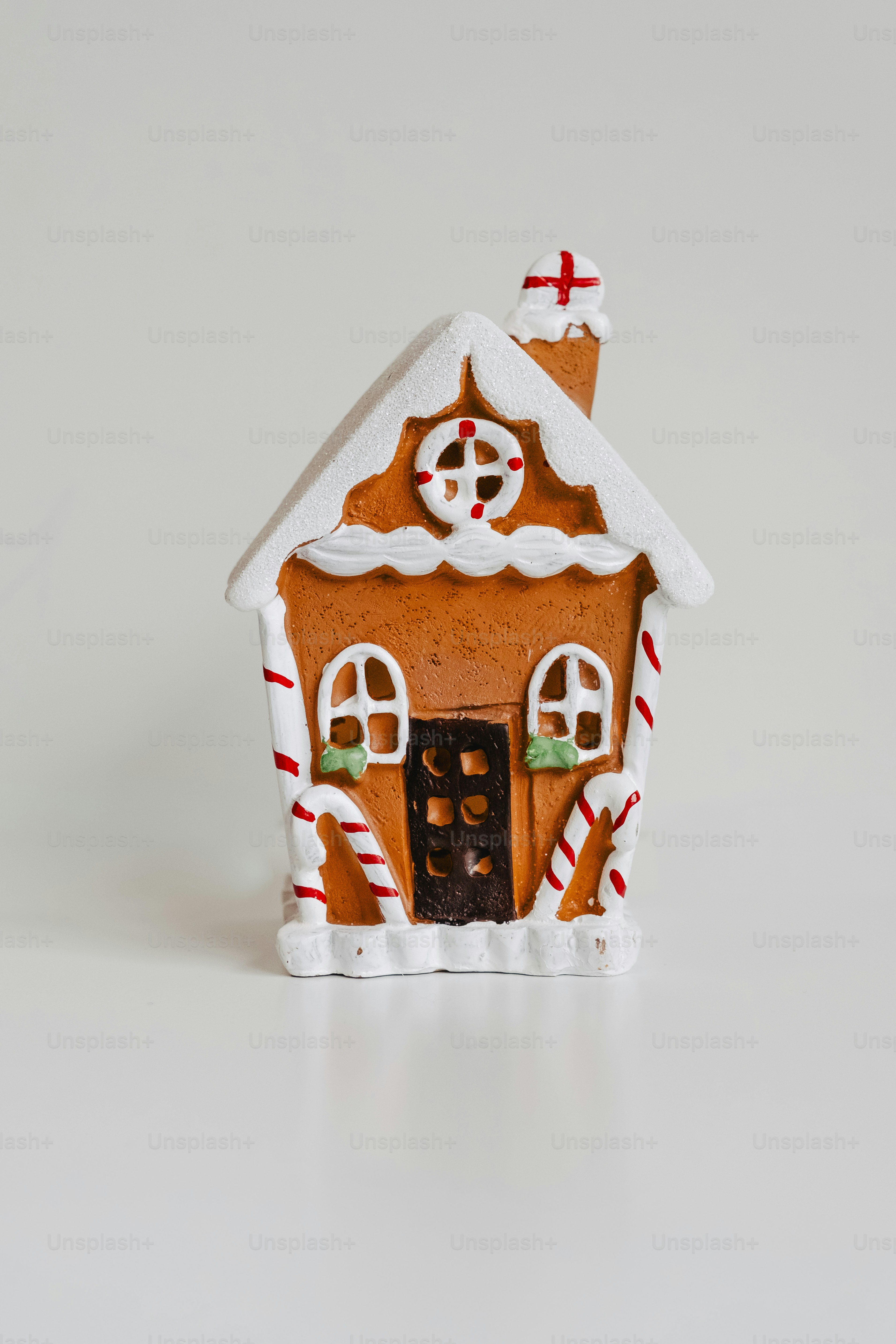 A small gingerbread house with white icing decorations.