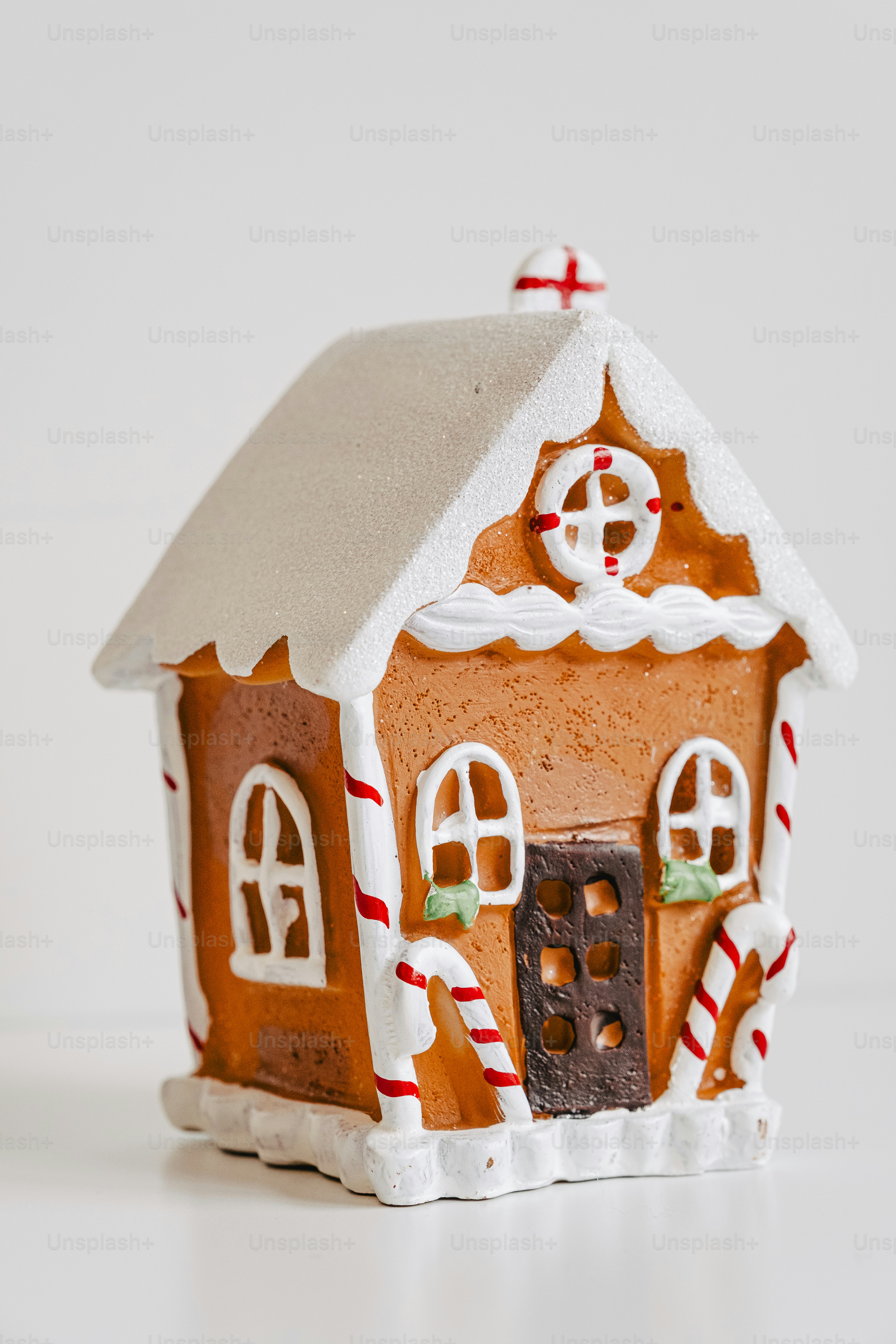 A small gingerbread house with white icing decorations. photo ...