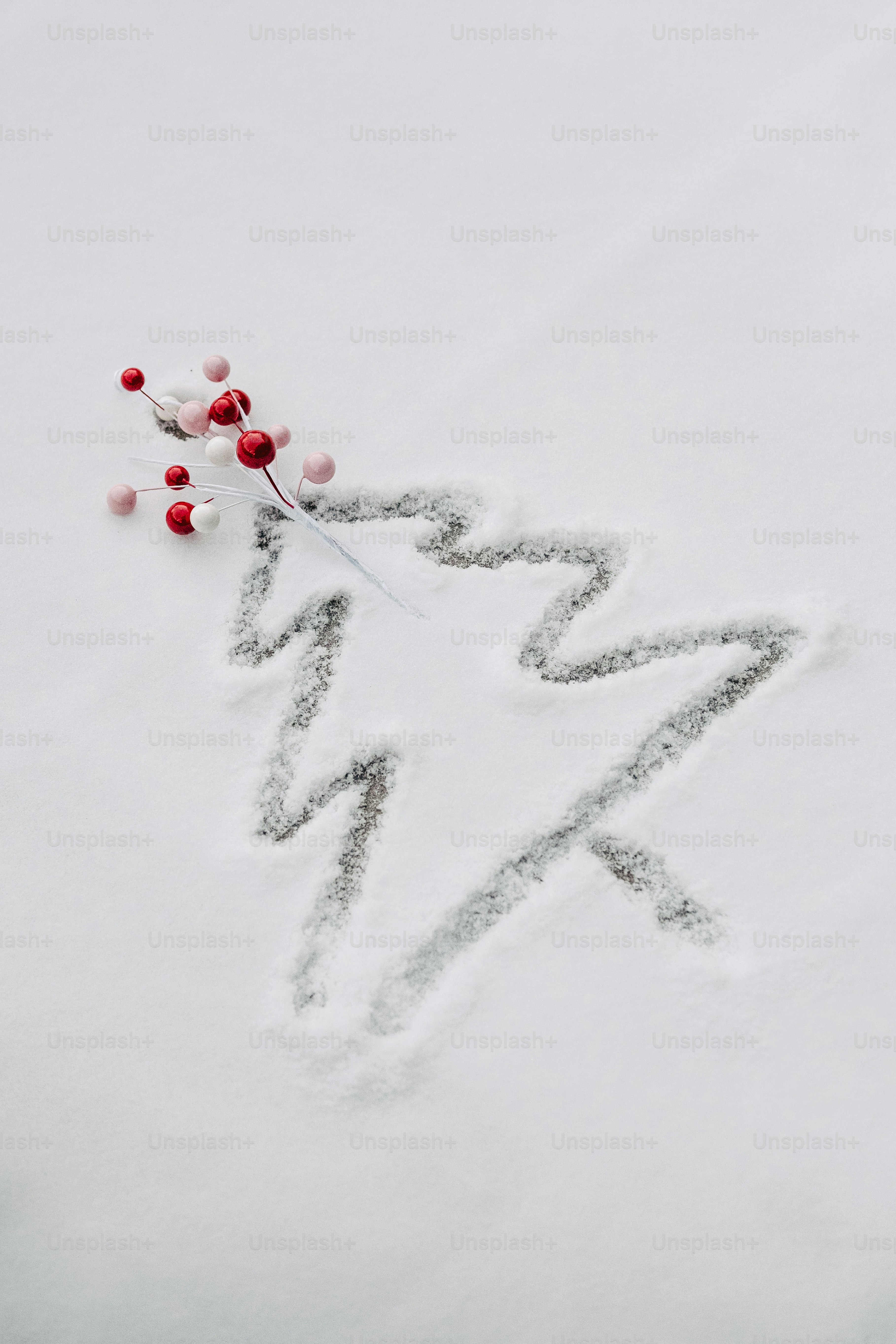 Christmas tree drawn in snow with festive berries