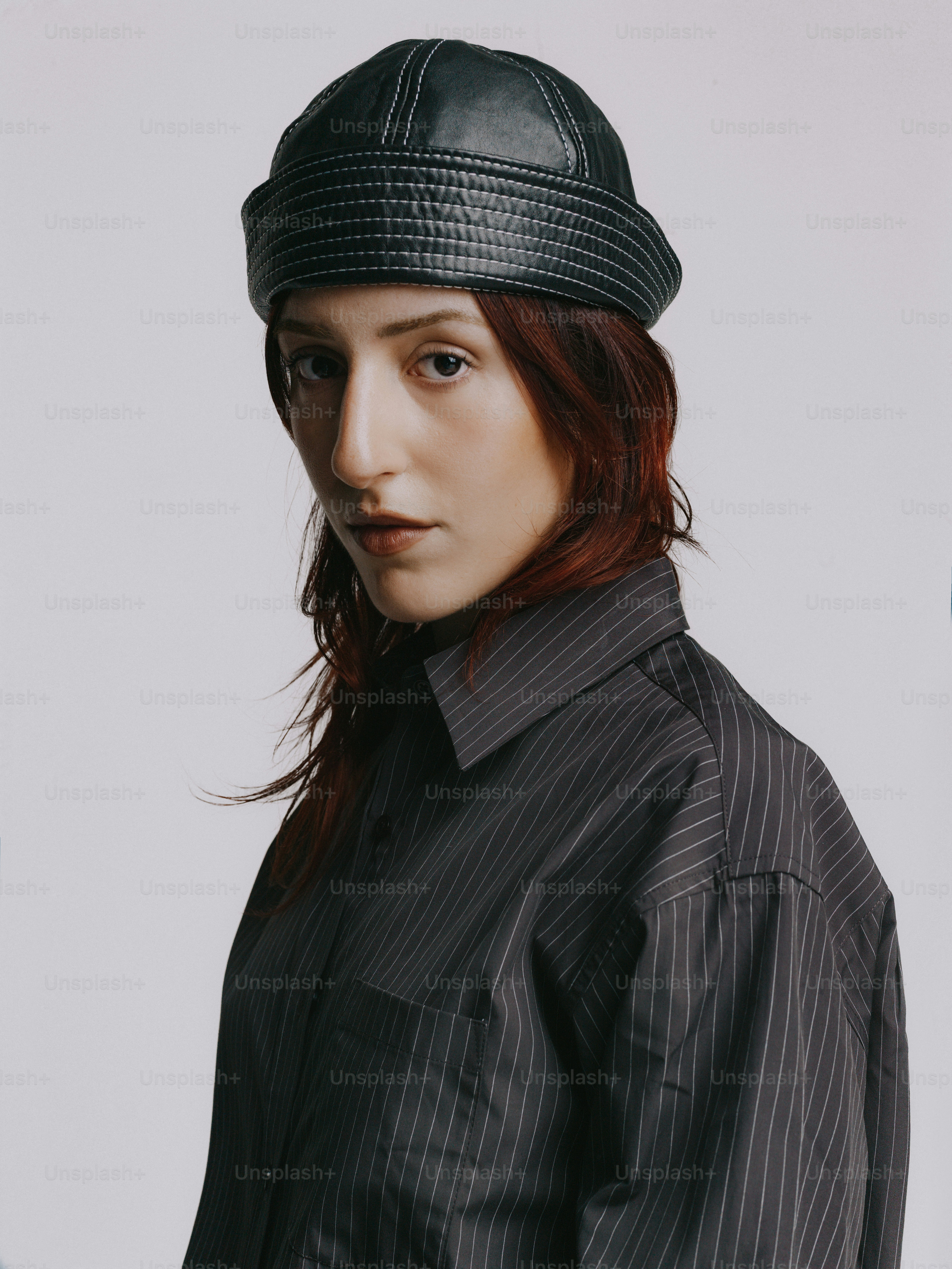 Una donna con un berretto di pelle nera e una camicia a righe