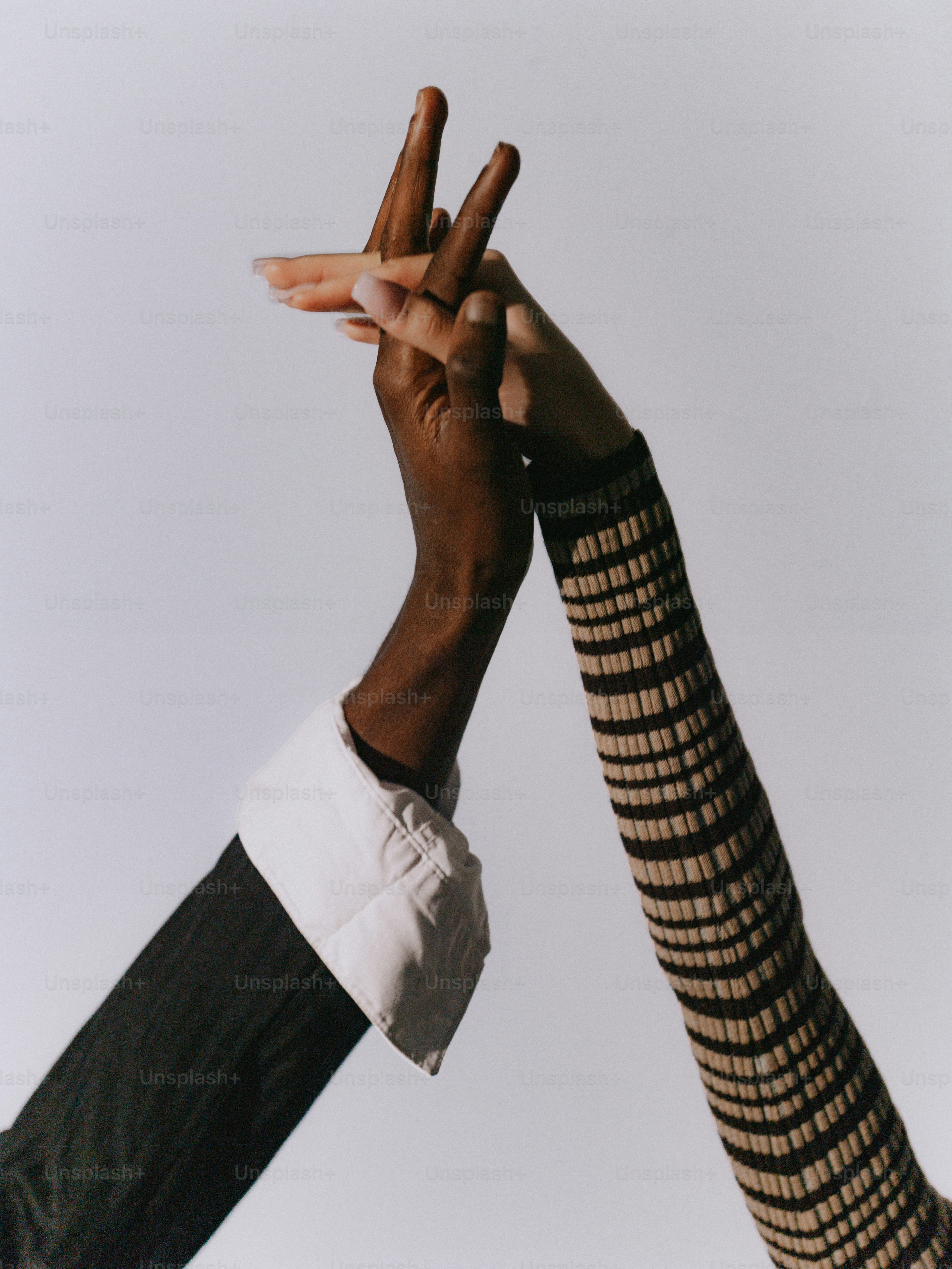 Two hands clasped together against a white background