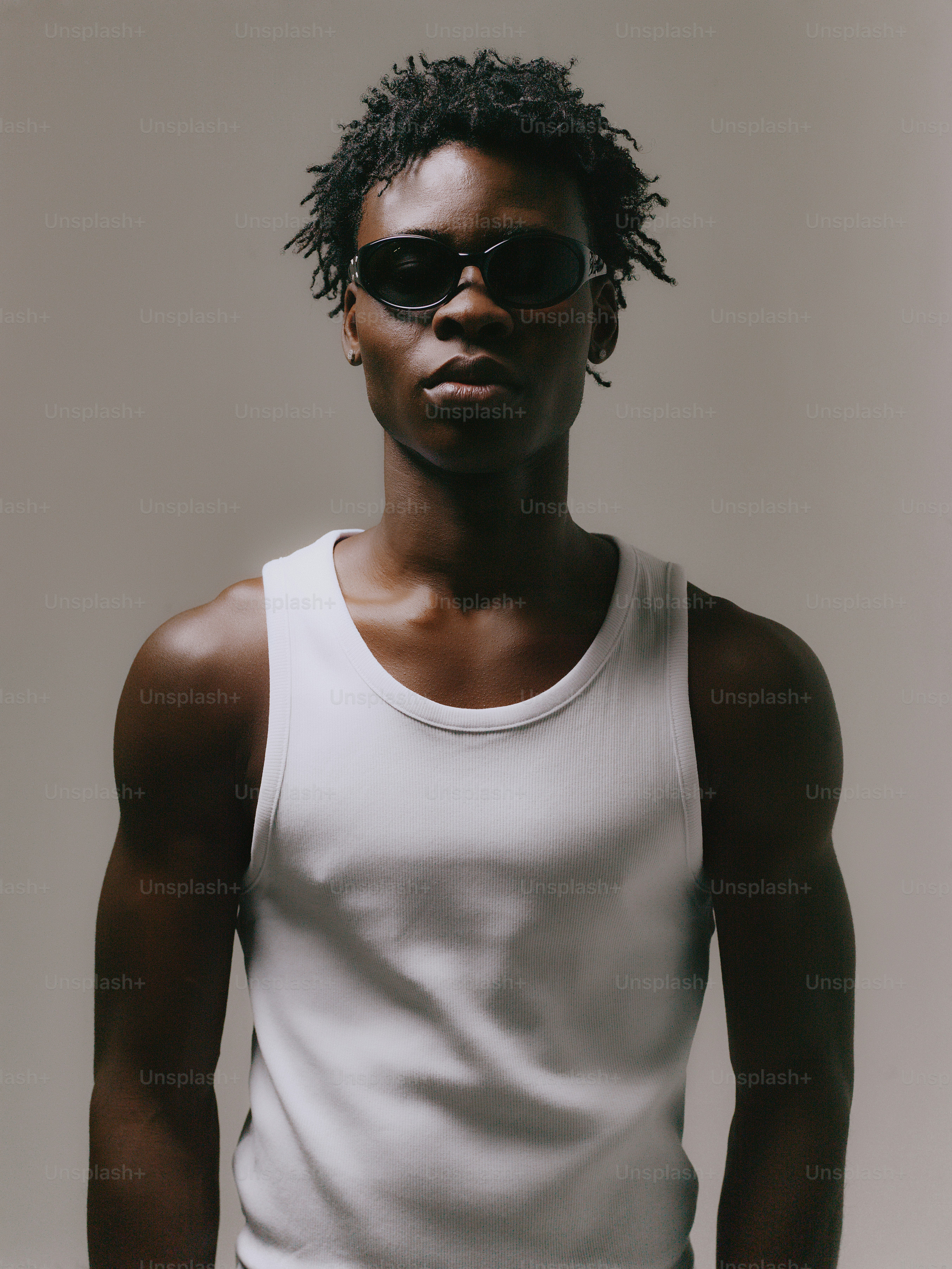 Joven con gafas de sol y una camiseta blanca de tirantes