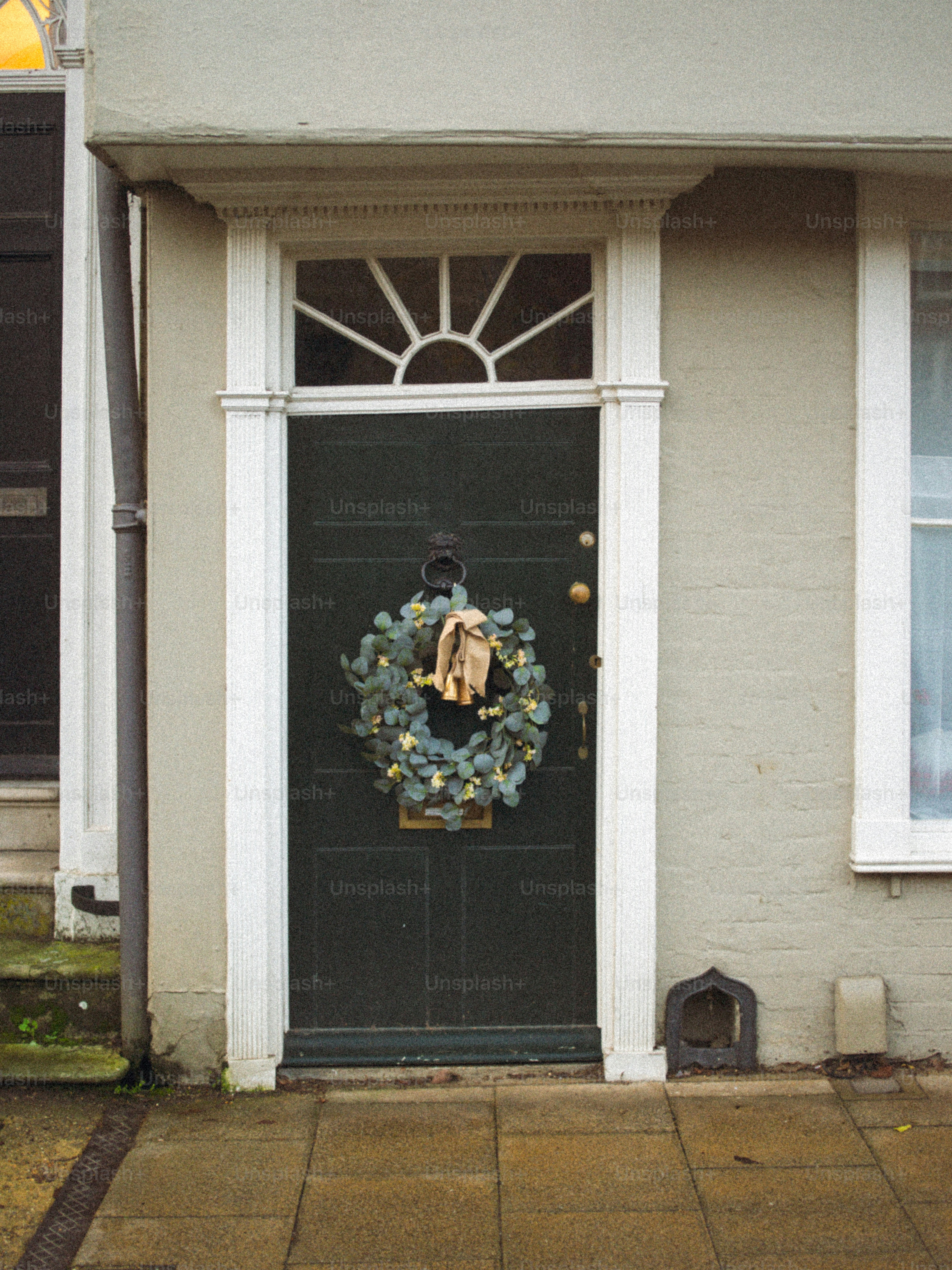A dark green door with a festive wreath.