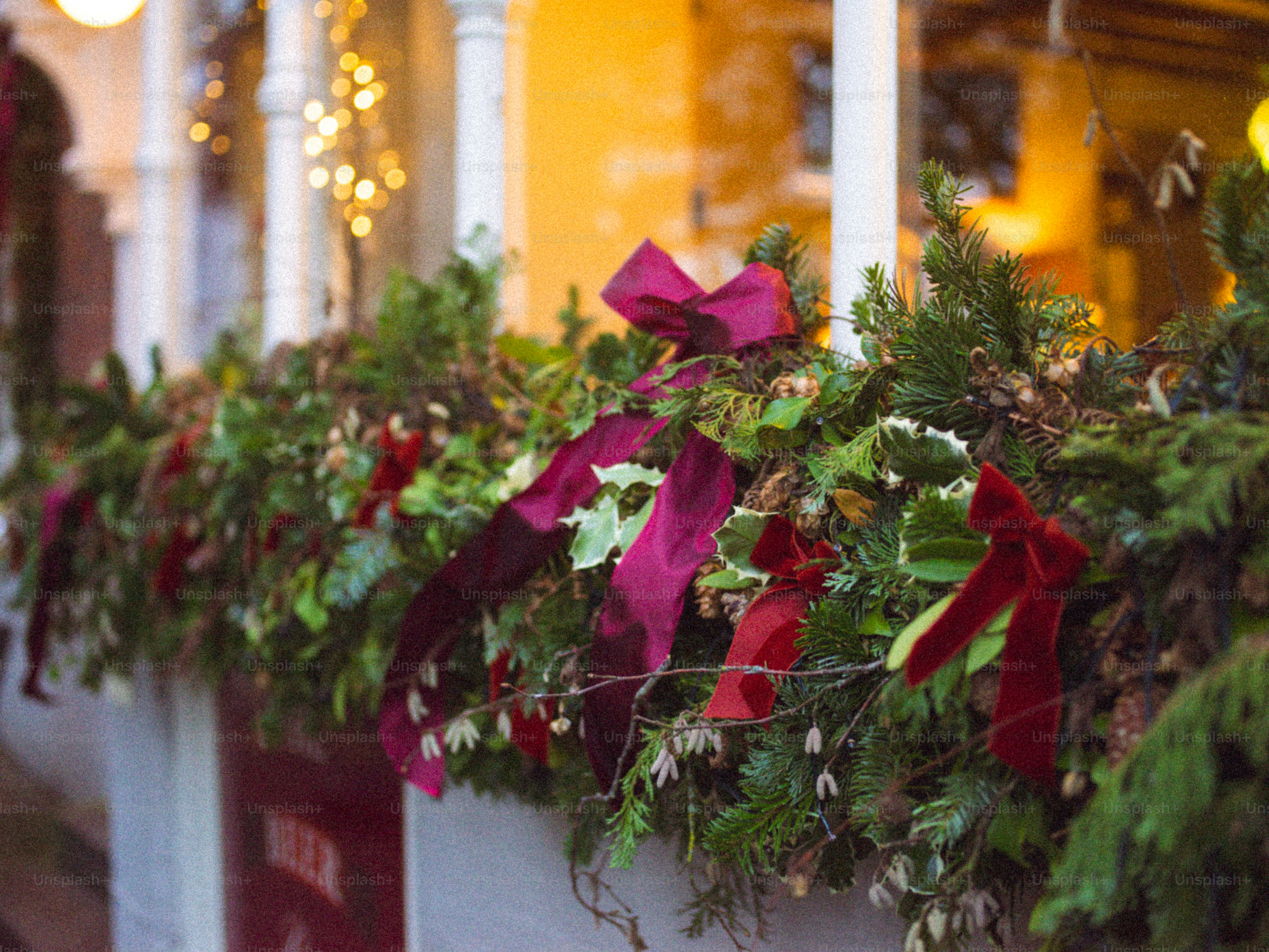Christmas garland with red bows on a porch railing