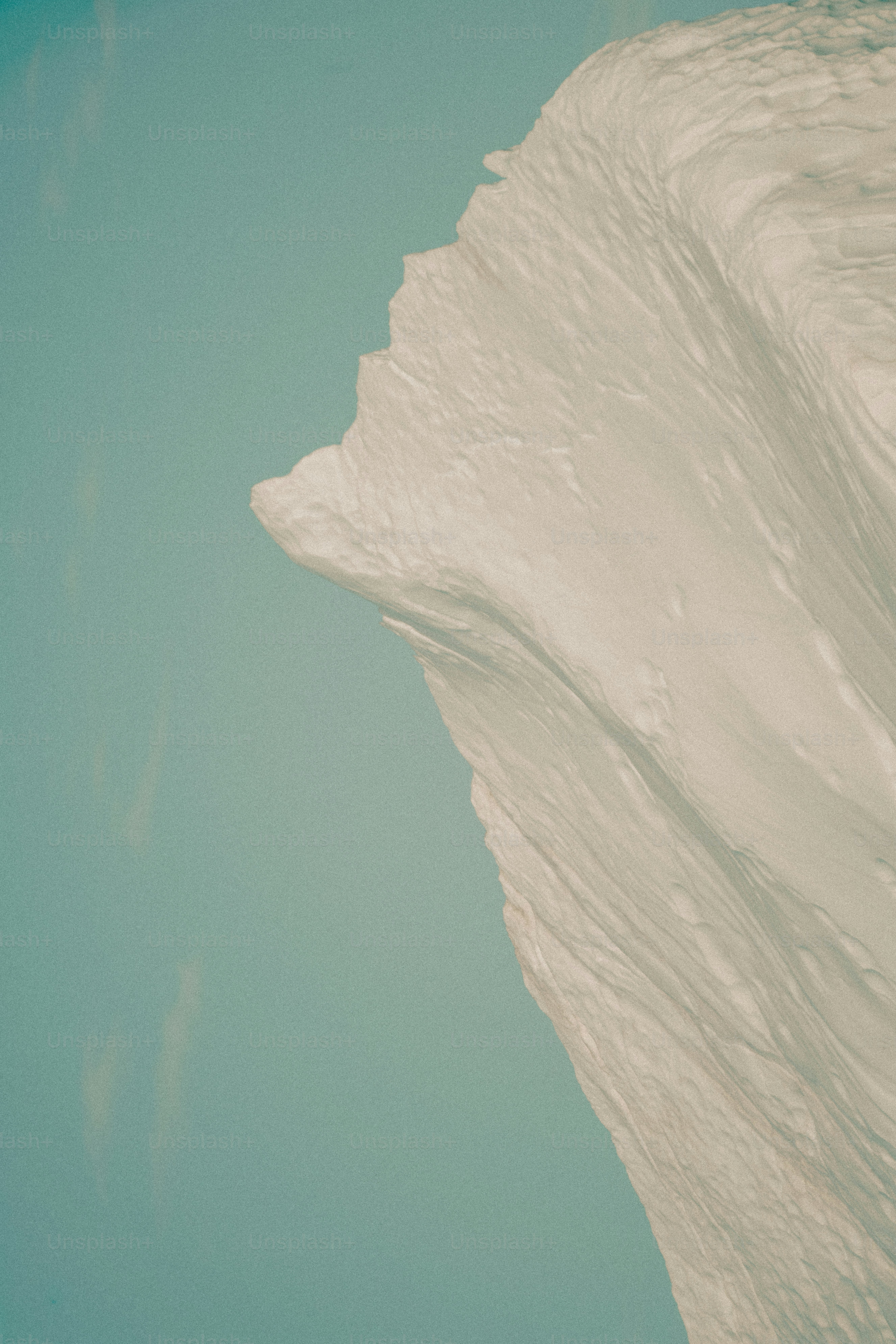 Close-up of a textured white surface against a blue sky.