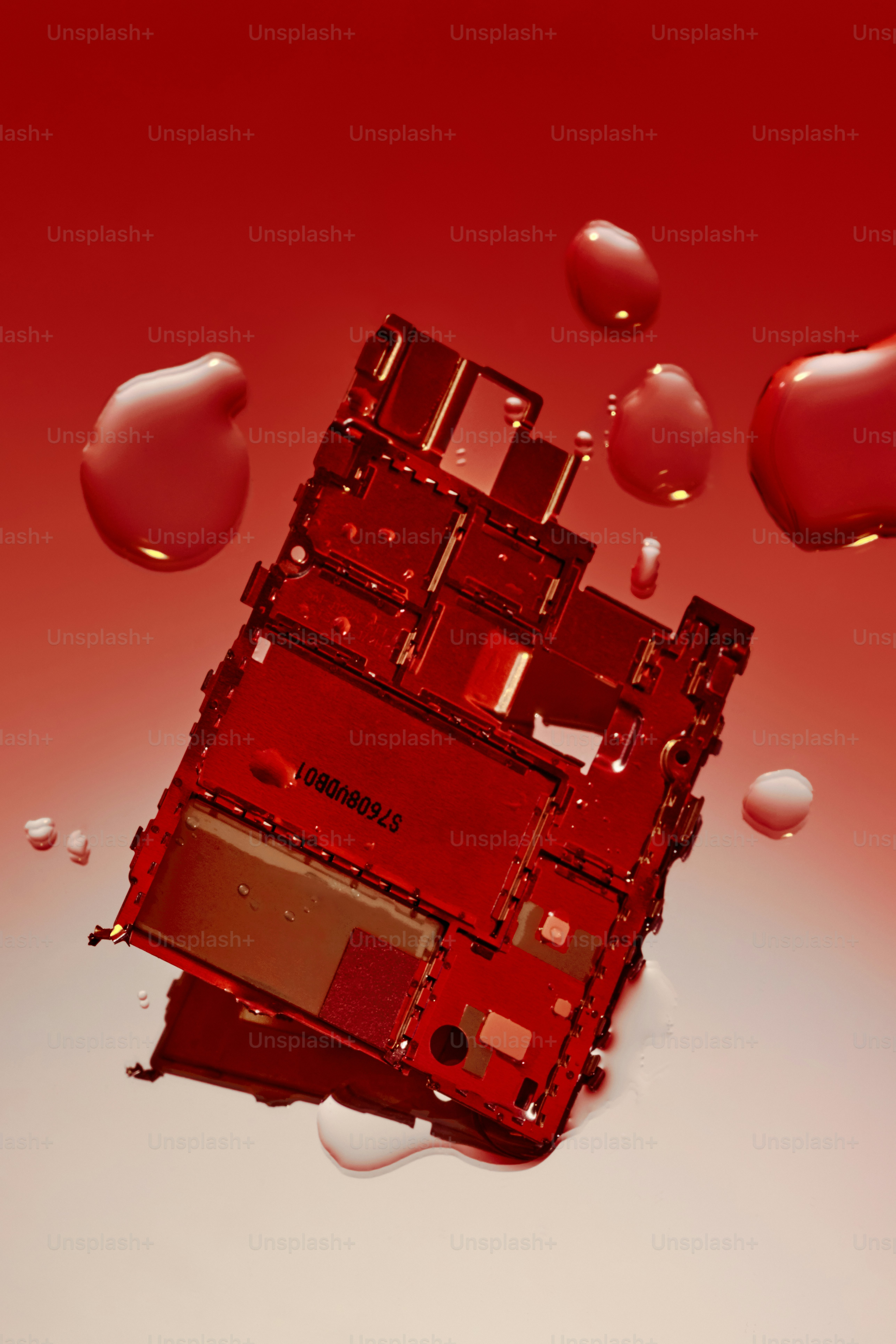 Red liquid drips onto a disassembled electronic device.