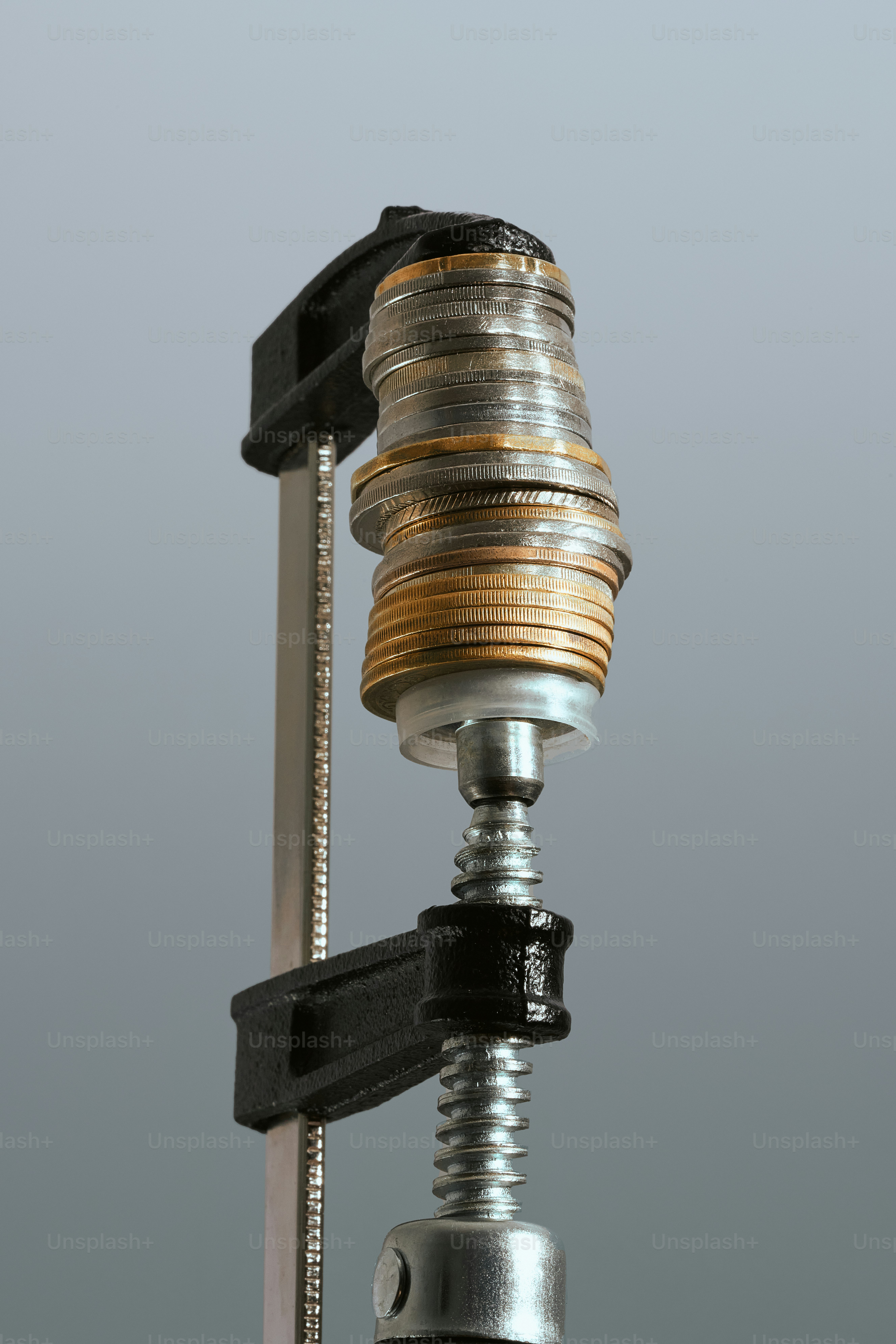 Pila de monedas comprimida por una pinza