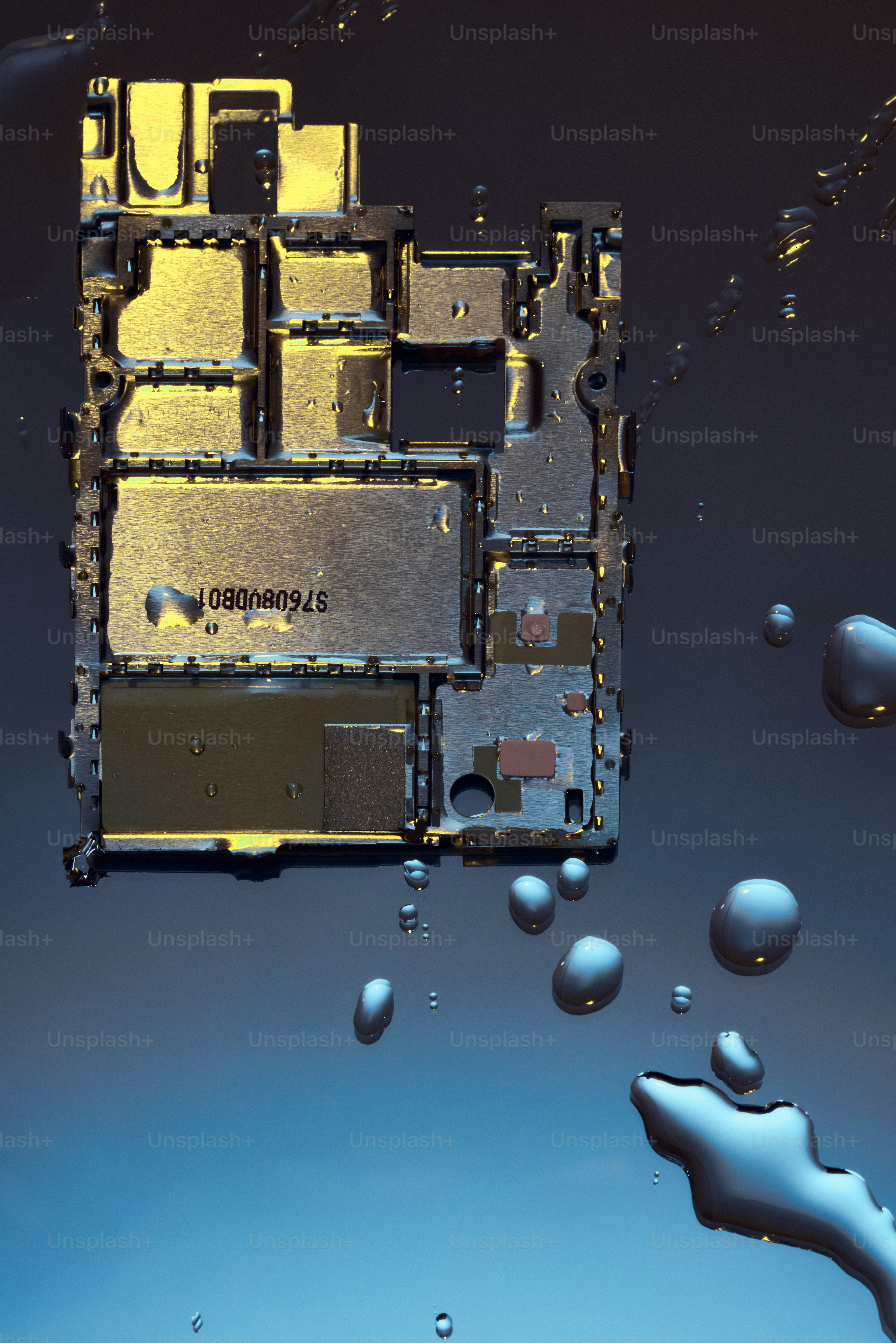 Circuit board with water droplets on dark background